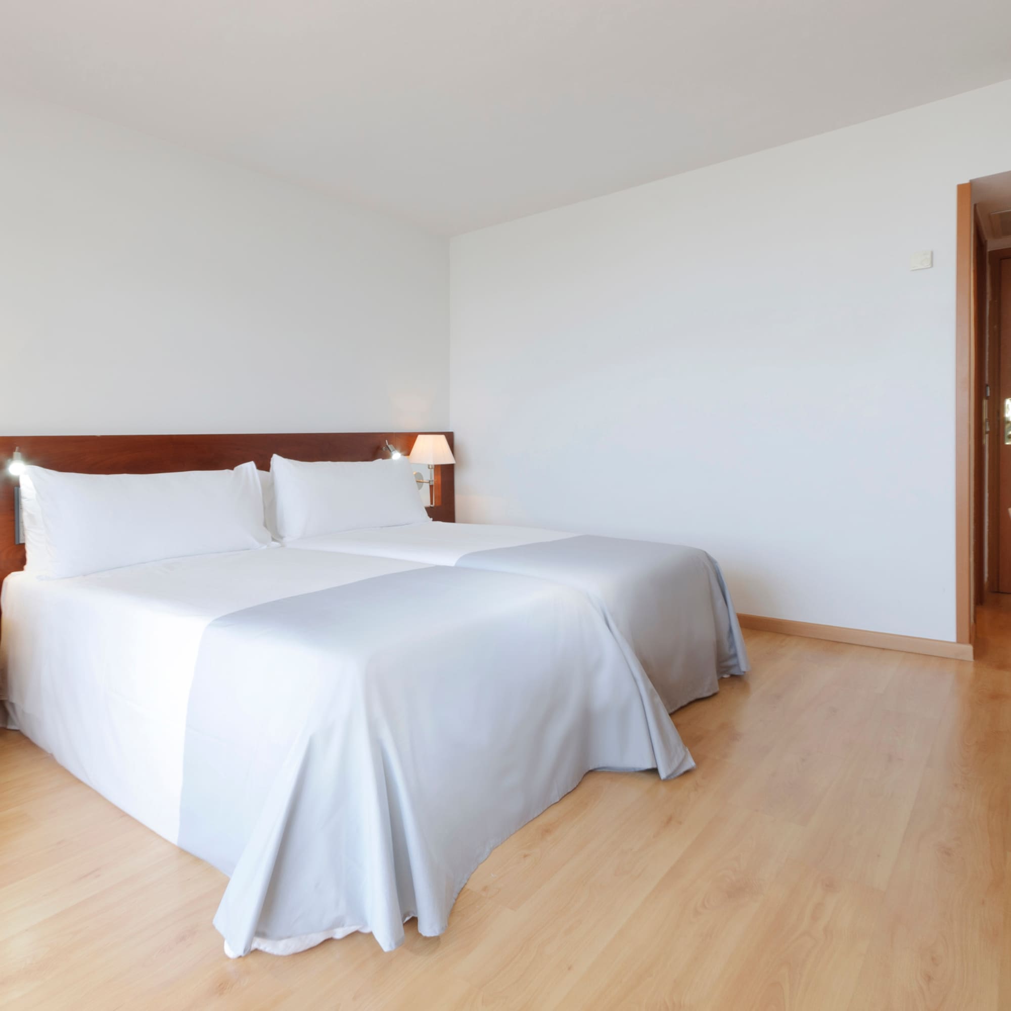 a room with two beds and a wood floor