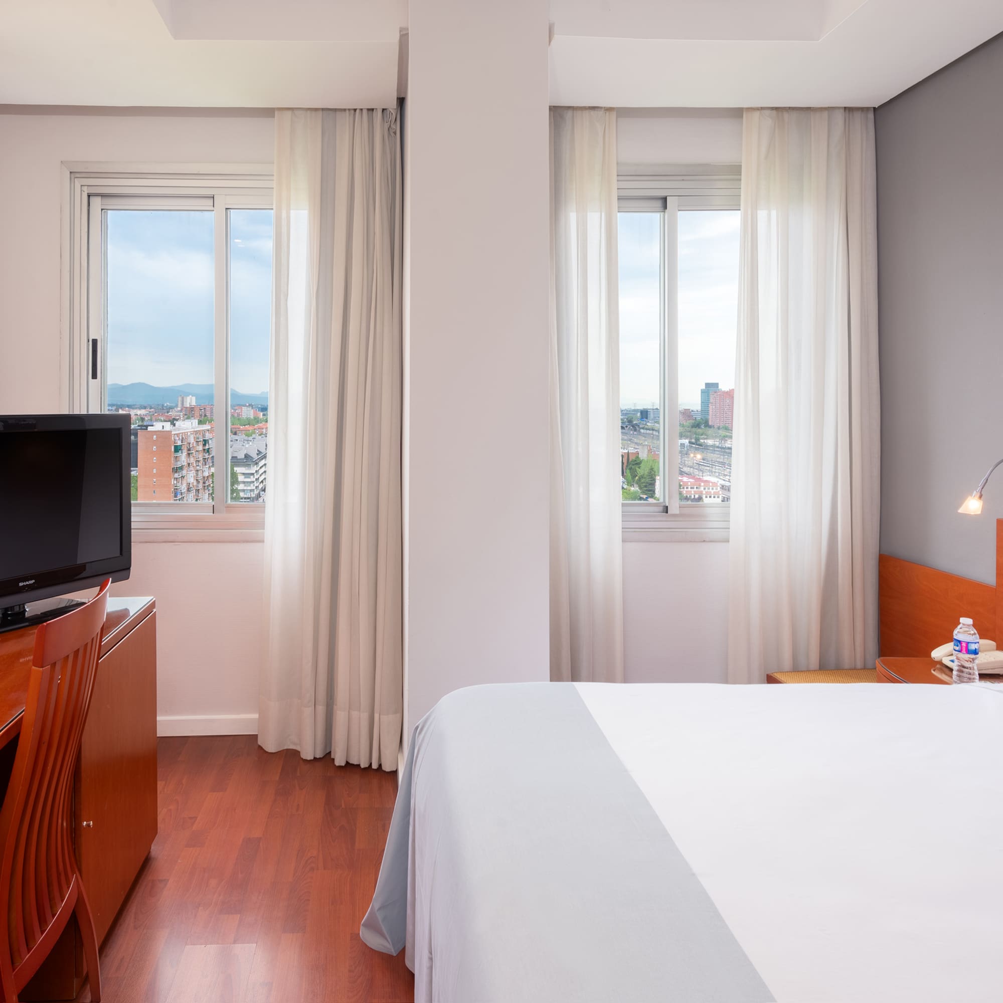 a bedroom with a television and a window