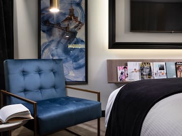 a blue chair next to a bed