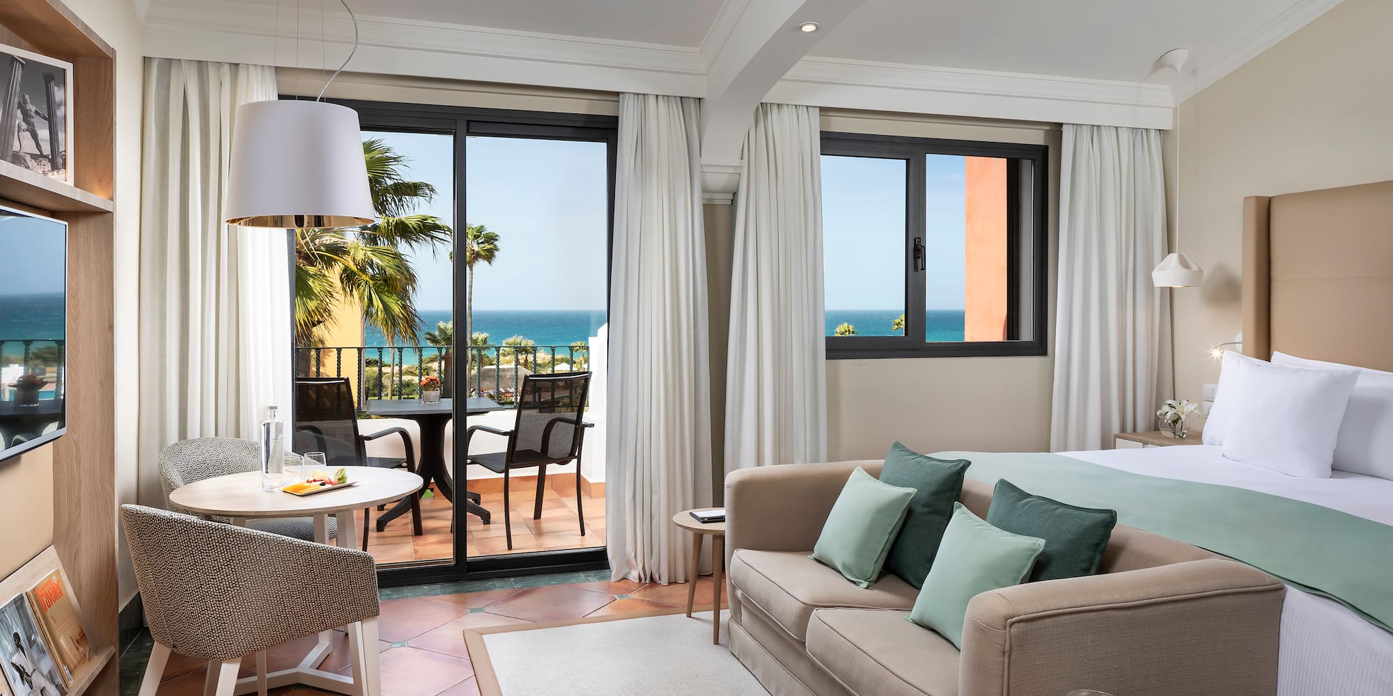 a room with a bed and a table and chairs