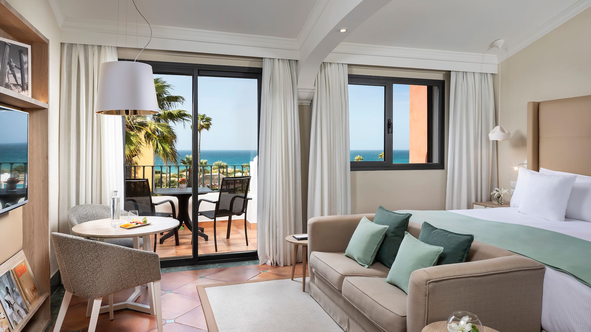 a room with a bed and a table and chairs