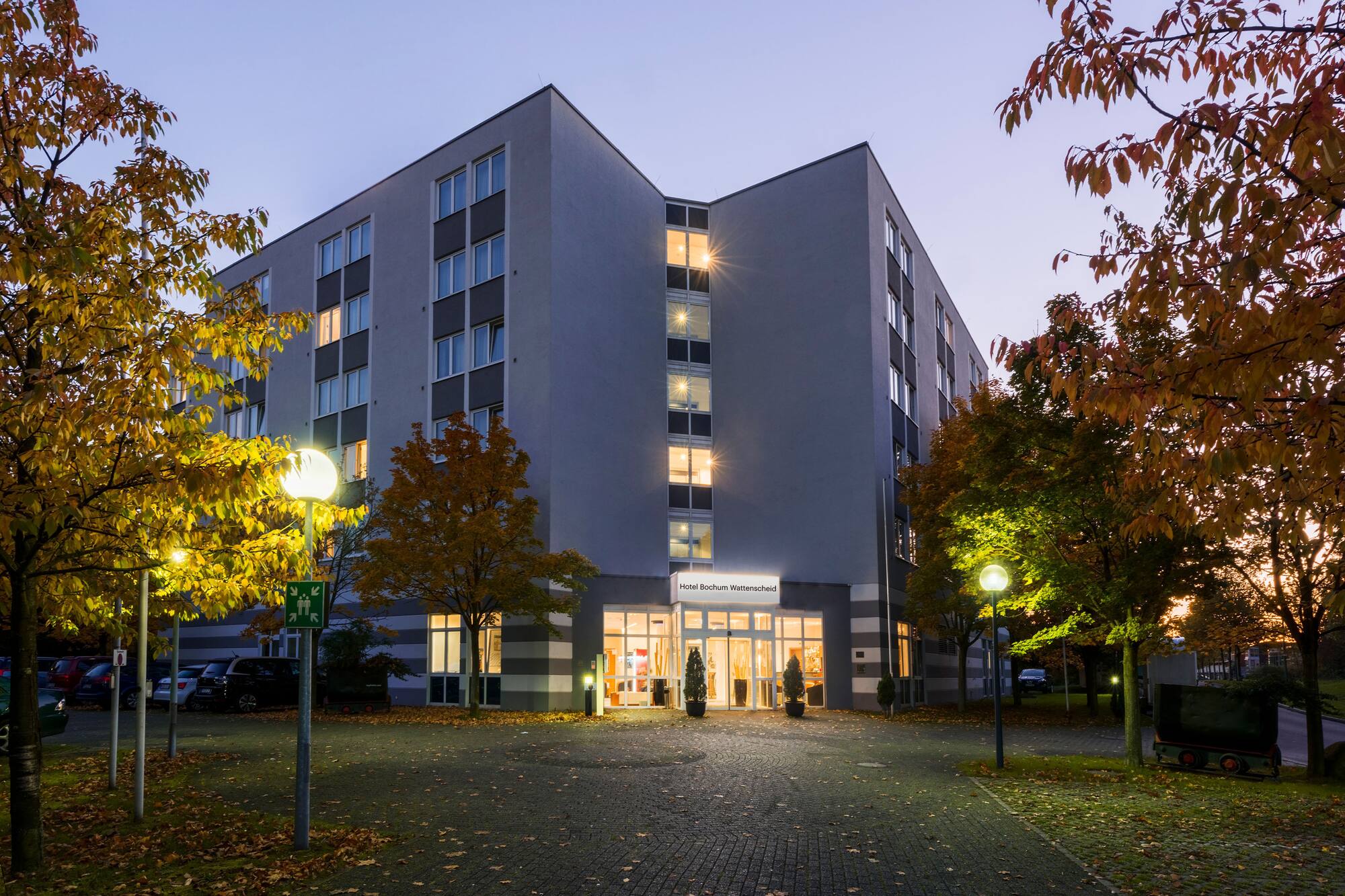 Hotel Bochum Wattenscheid, modern, evening, autumn trees, illuminated.
