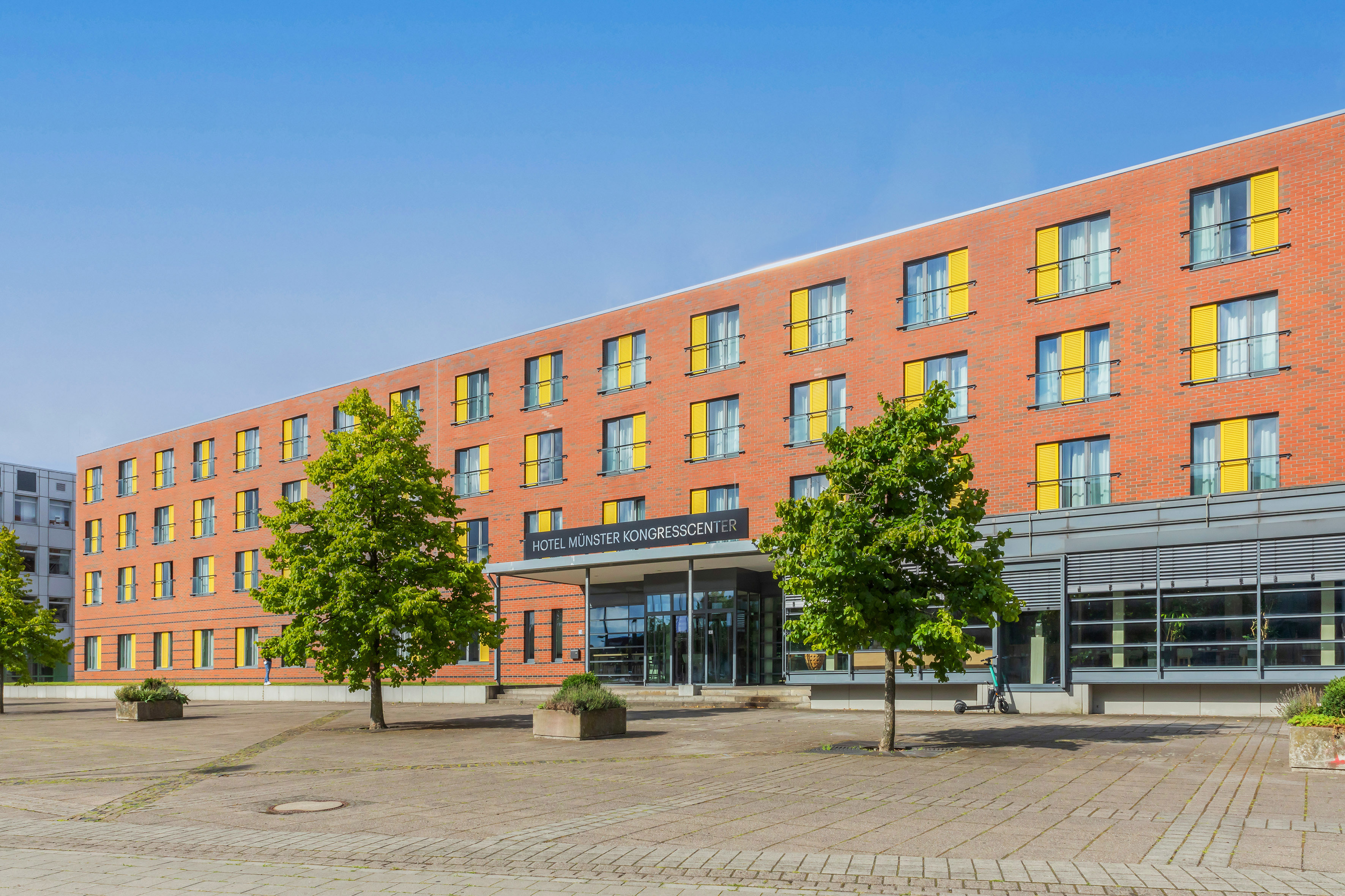 Hotel Münster Kongresscenter: Red brick building, yellow shutters, modern entrance.
