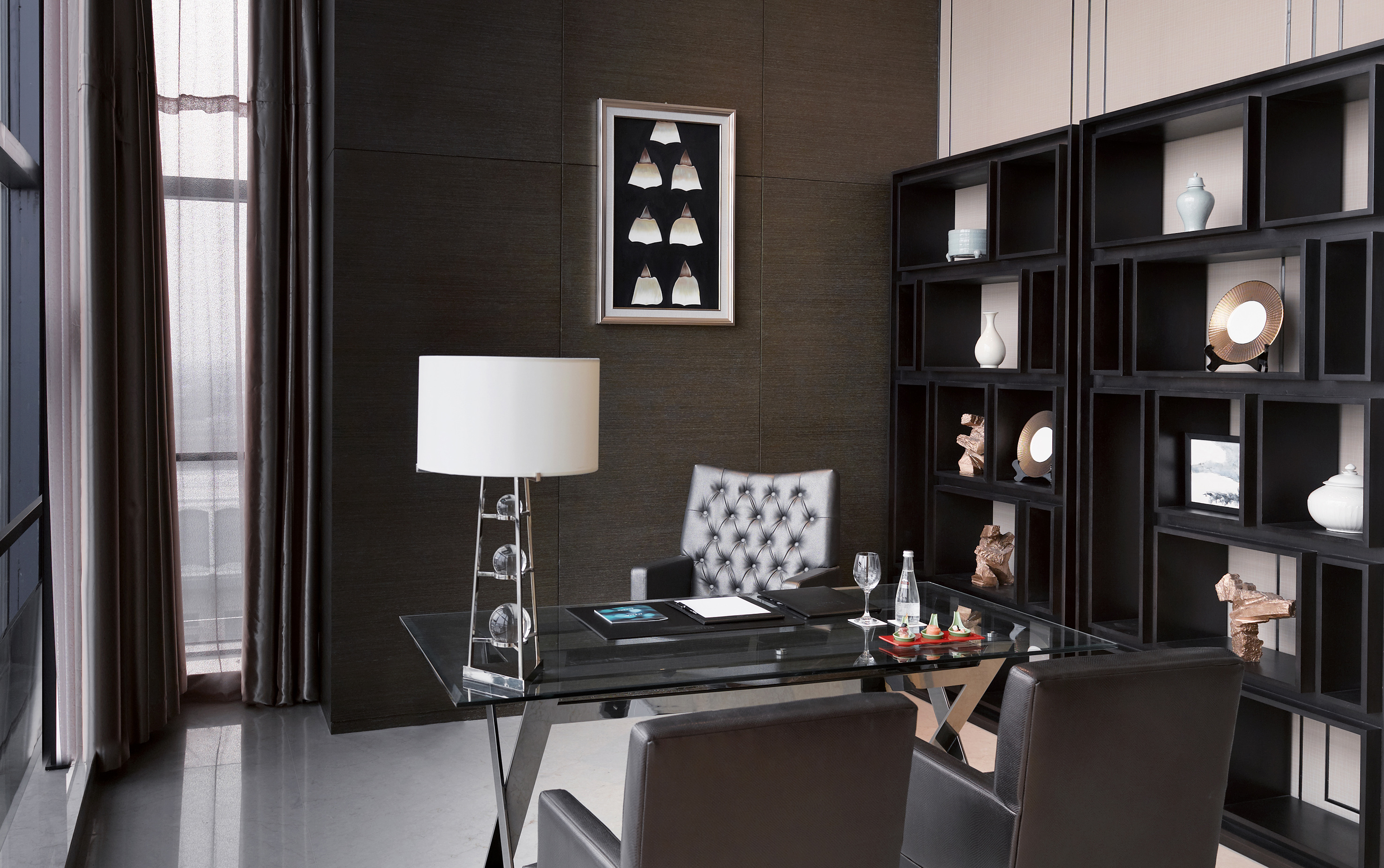 a desk with a lamp and a bookcase in a room