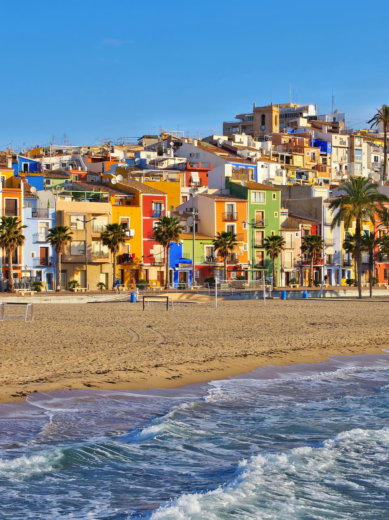 a beach with buildings and palm trees