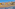 a beach with buildings and palm trees