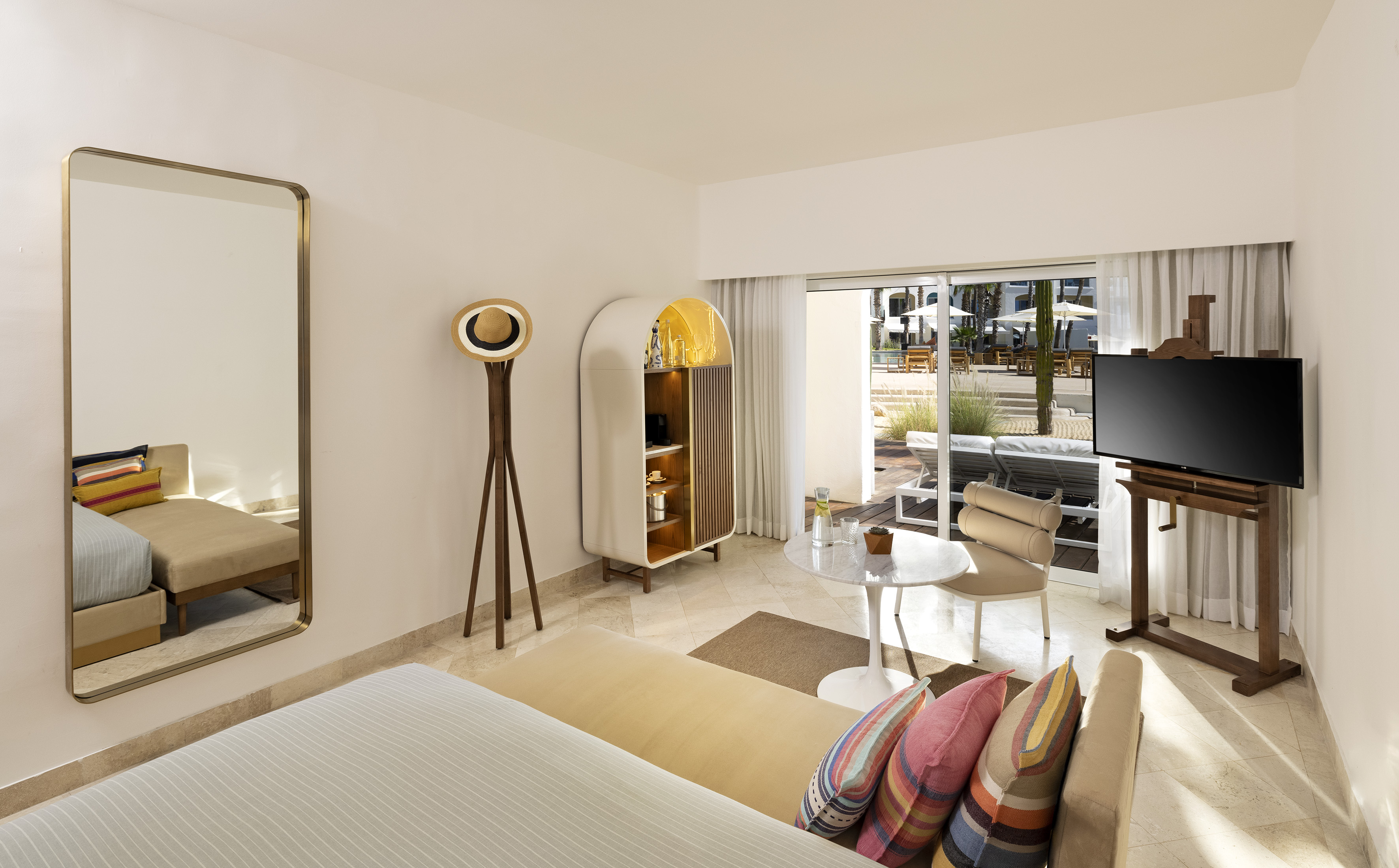Luxury hotel suite with modern design, pool patio, and stylish mini-bar.
