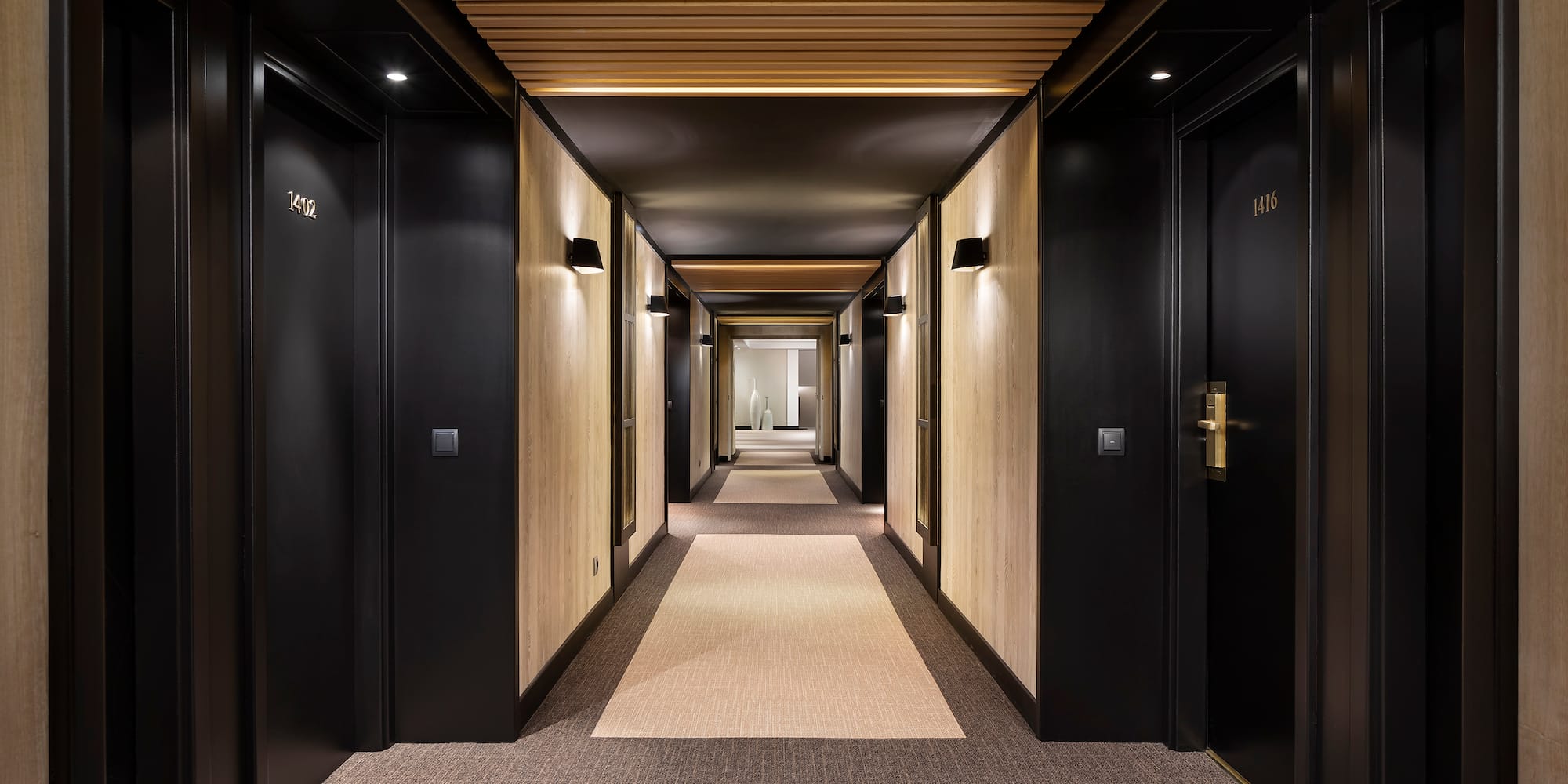 a hallway with black doors and carpet