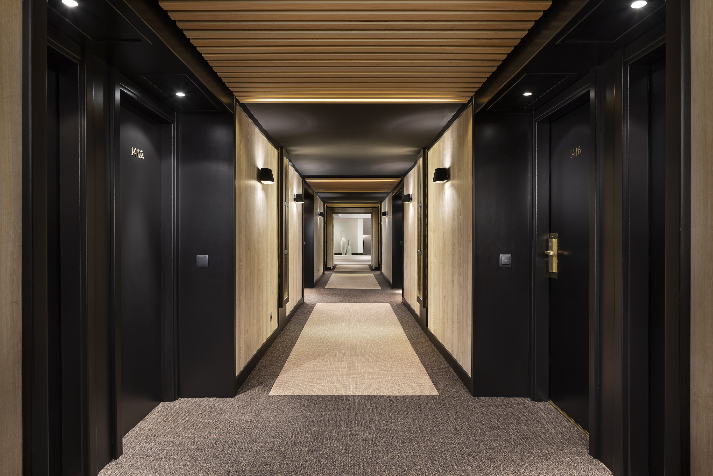 a hallway with black doors and carpet