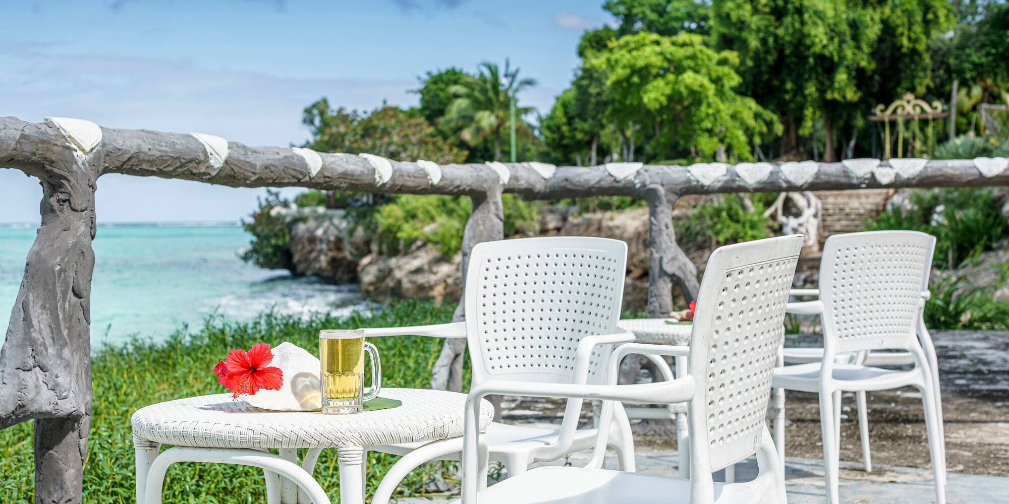 a table and chairs on a patio by the ocean