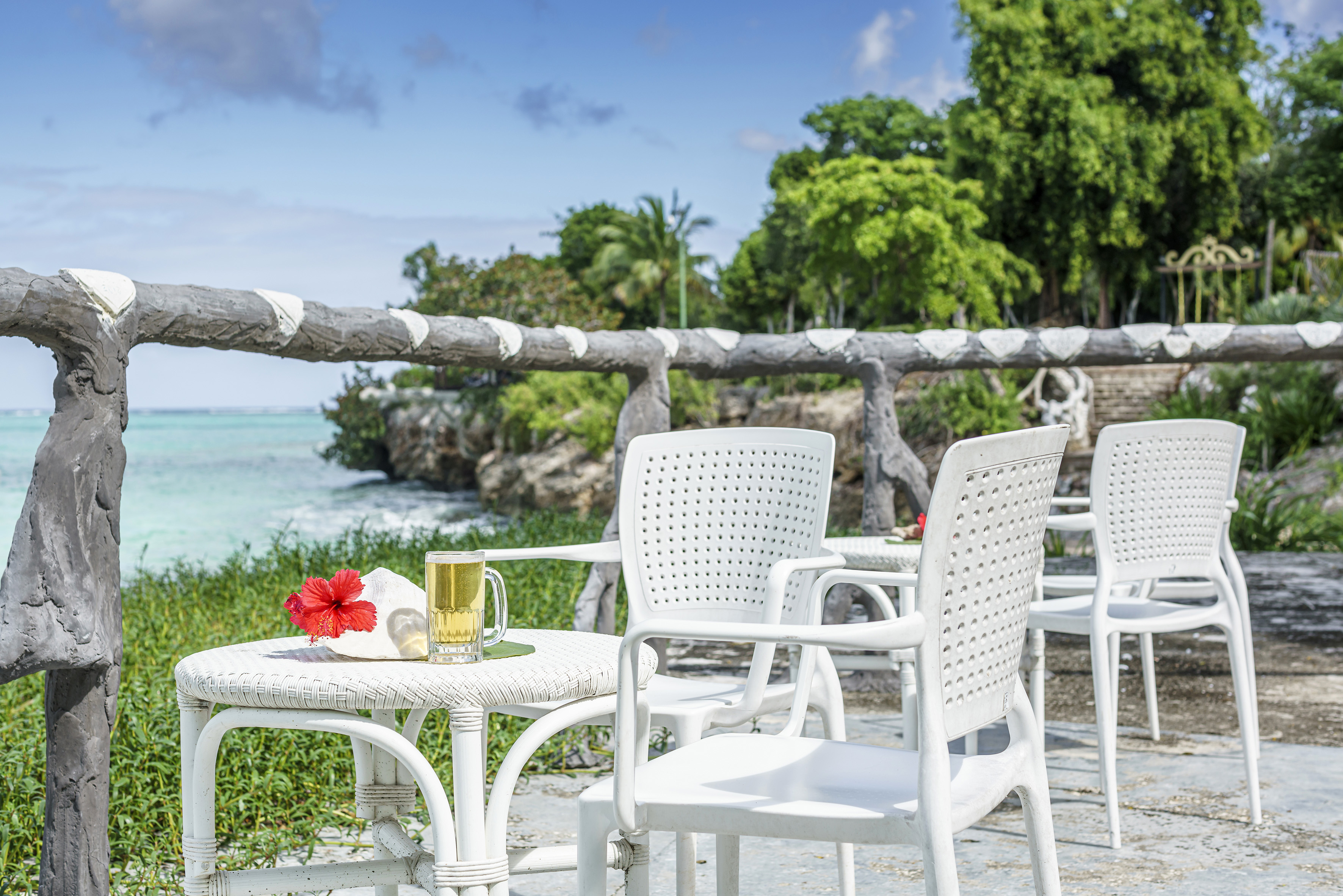 a table and chairs on a patio by the ocean
