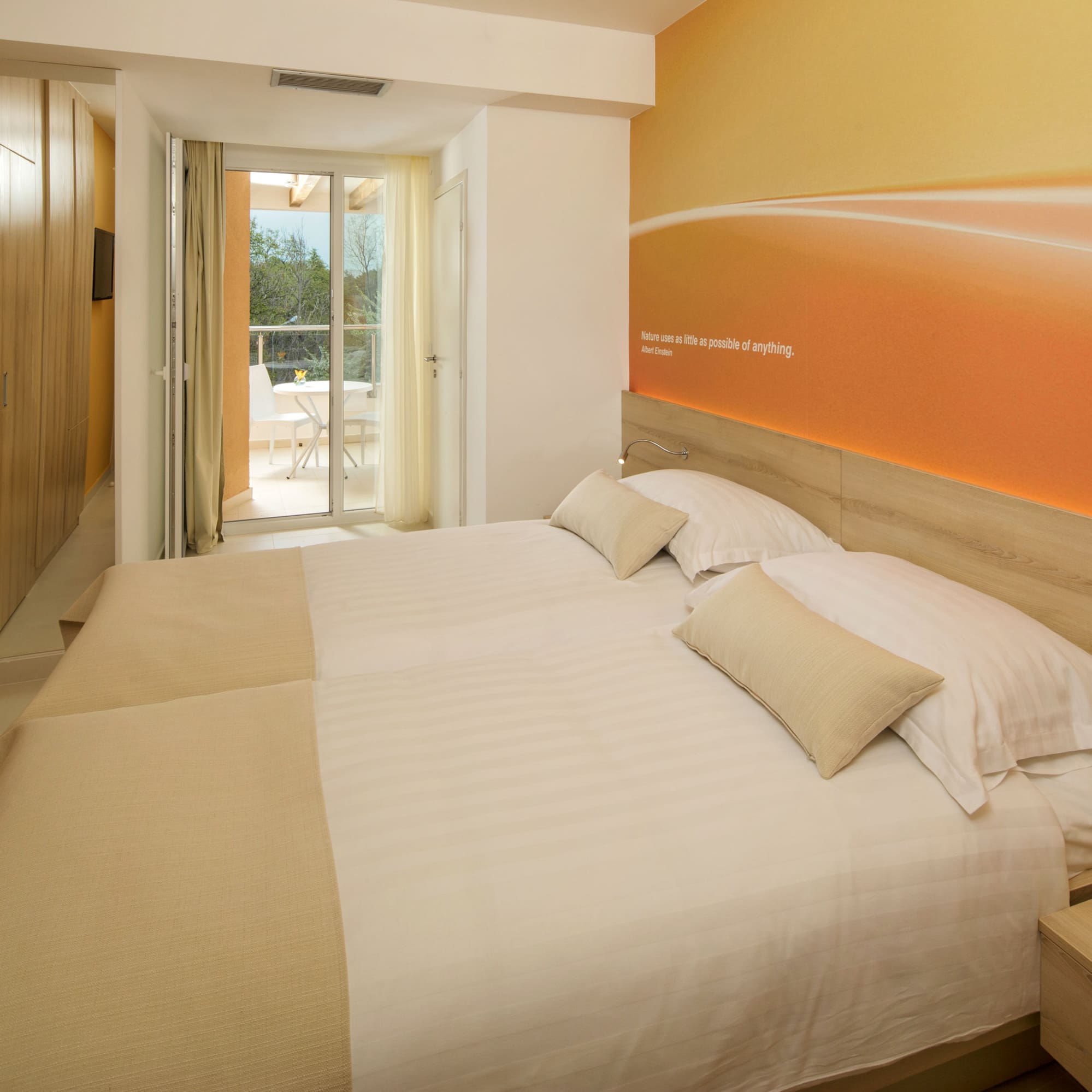 a bed with pillows and a wallpaper on the wall