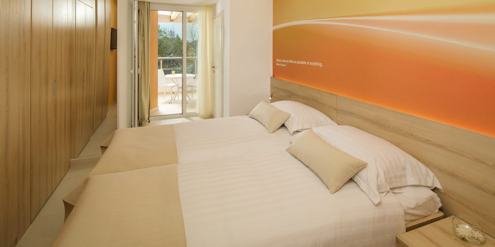 a bed with pillows and a wallpaper on the wall