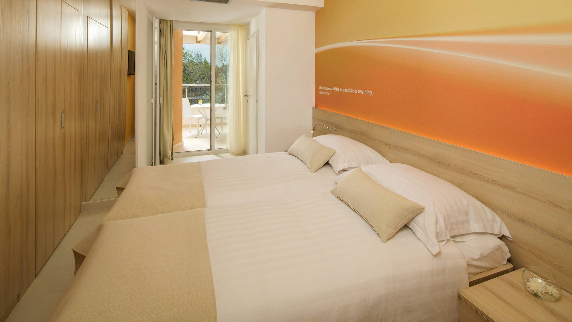 a bed with pillows and a wallpaper on the wall