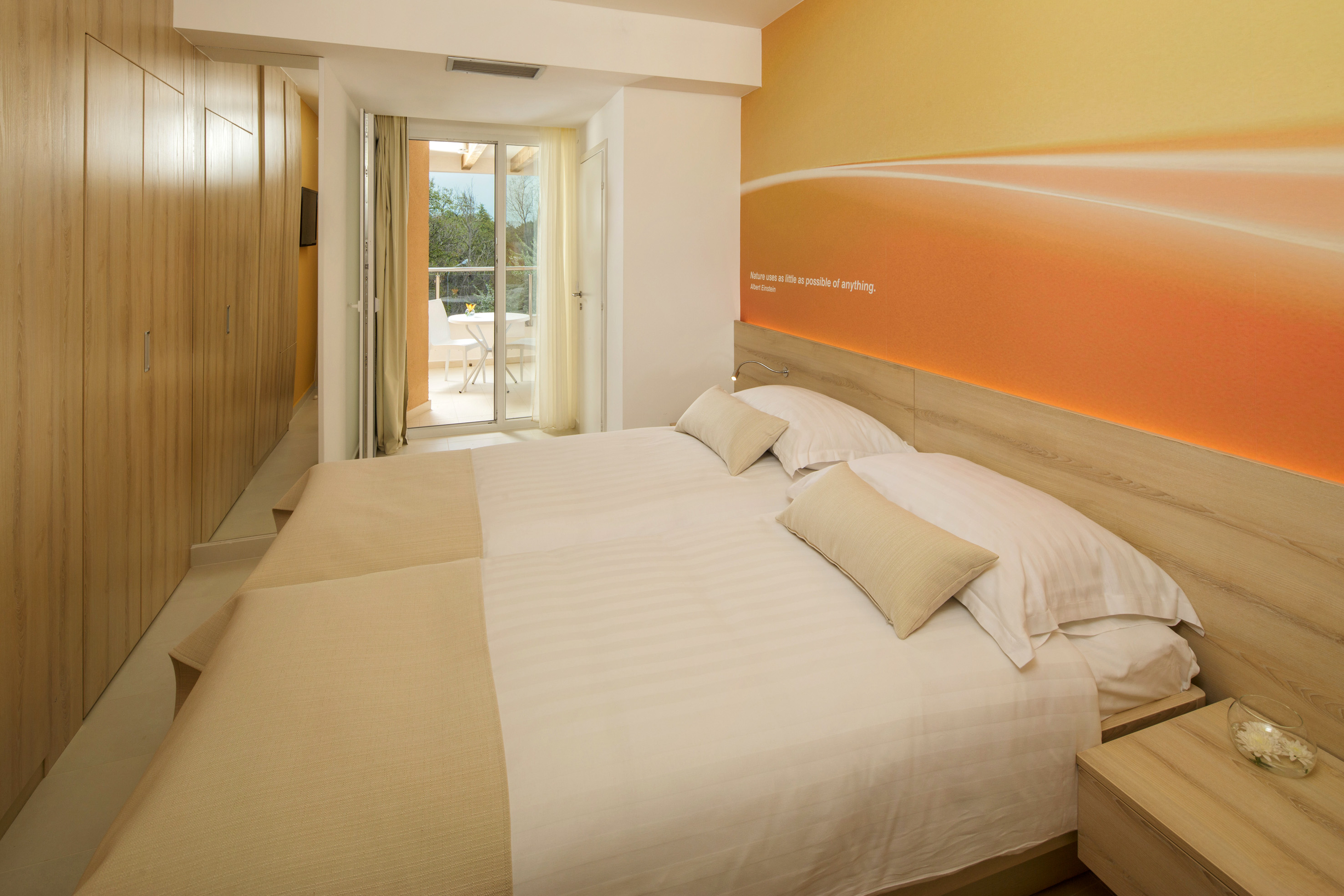 a bed with pillows and a wallpaper on the wall