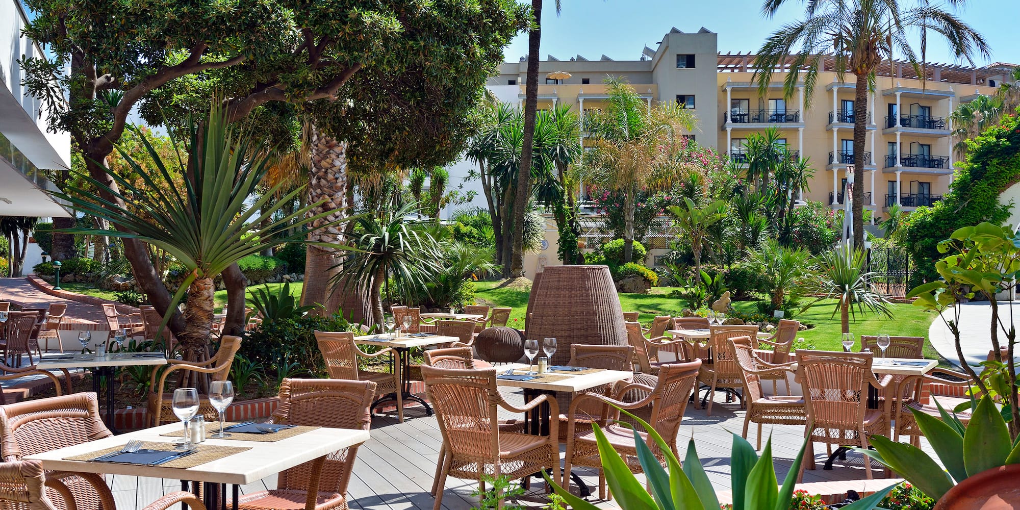 a patio with tables and chairs and trees