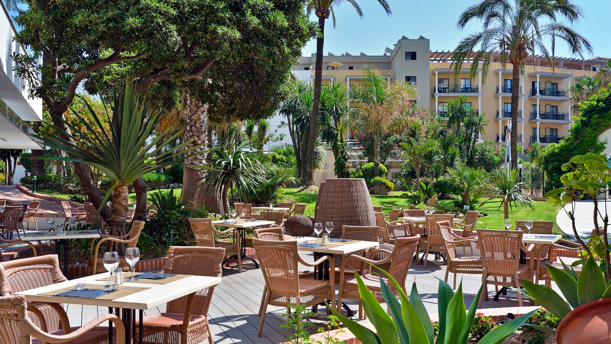 a patio with tables and chairs and trees
