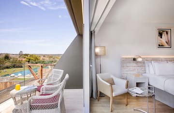 a room with a balcony and a table and chairs