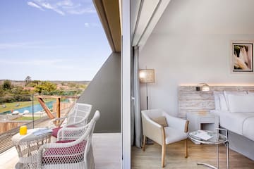 a room with a balcony and a table and chairs