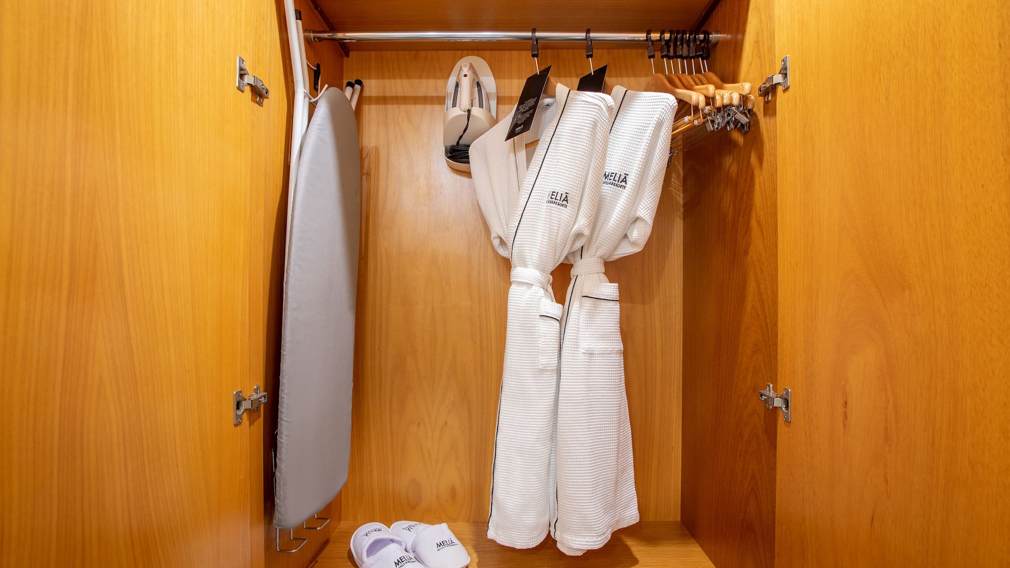 a closet with white bathrobes and slippers