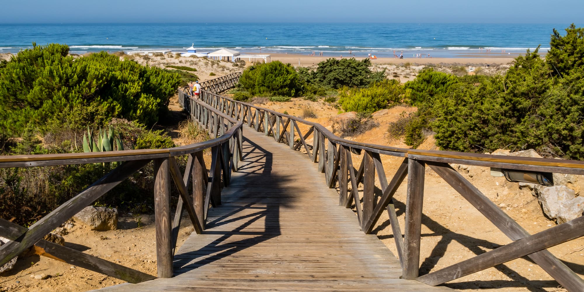 a wooden walkway leading to a beach
