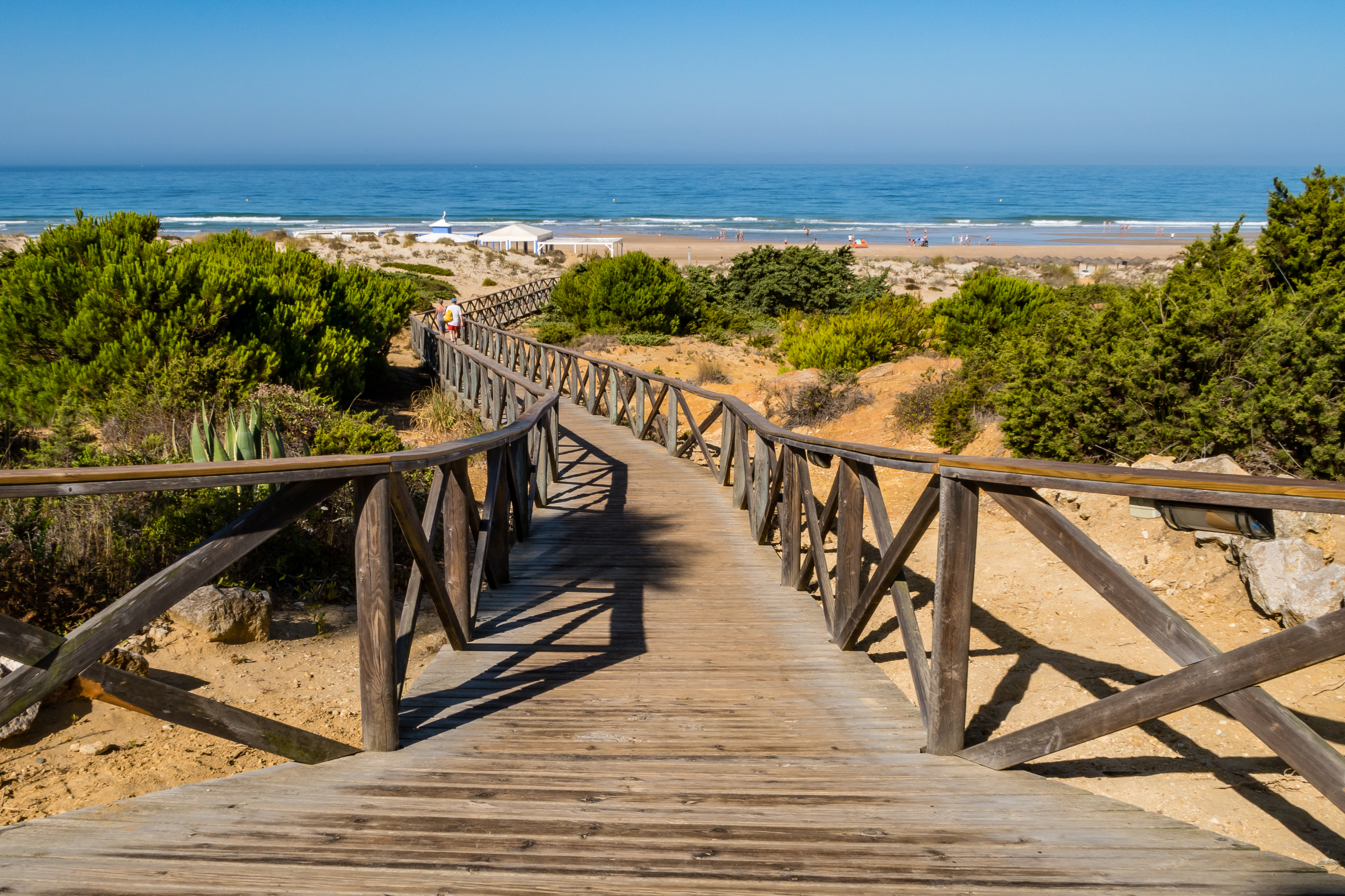 a wooden walkway leading to a beach