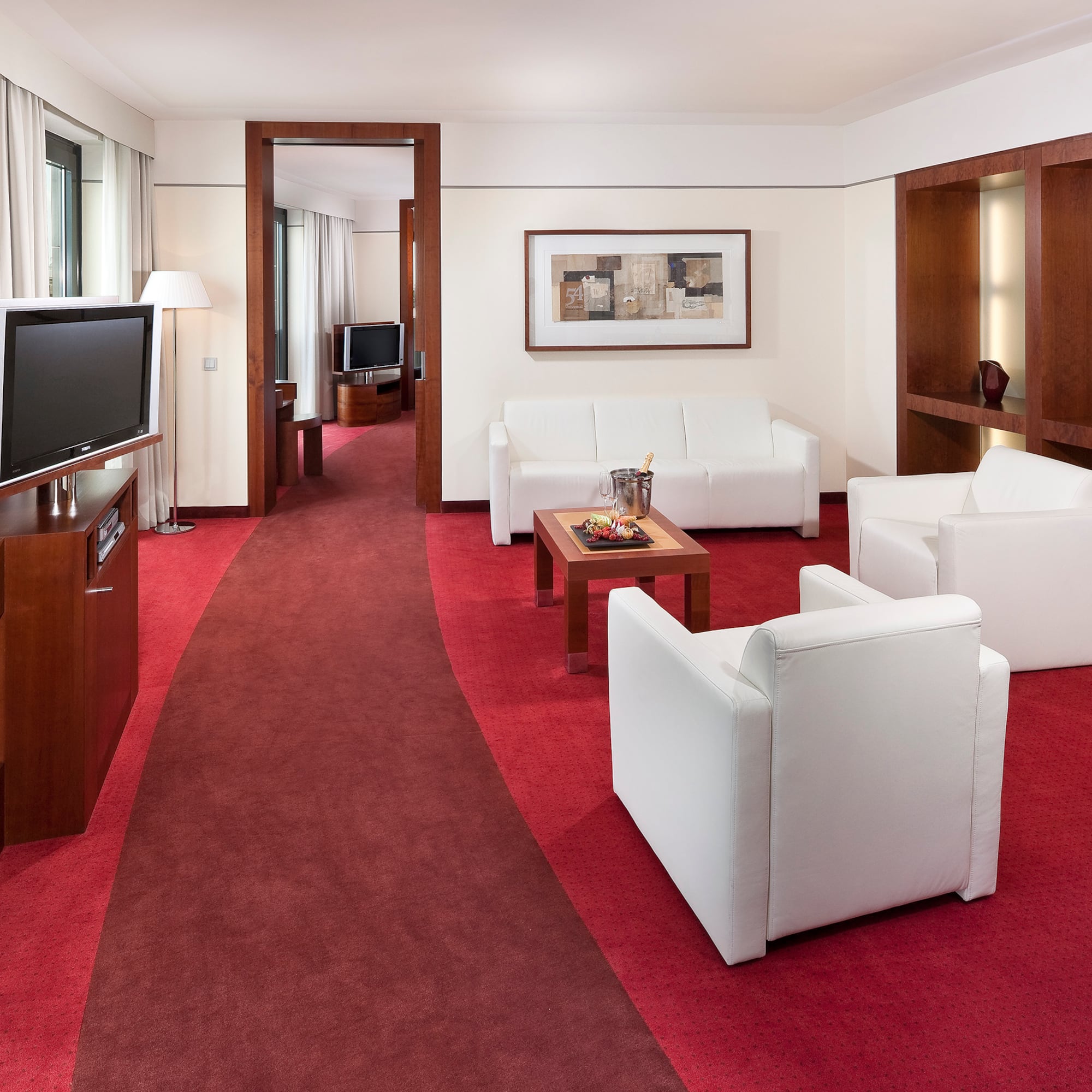 a room with white furniture and red carpet