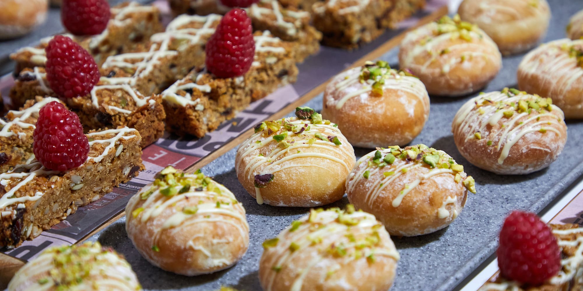 a tray of pastries with raspberries on top