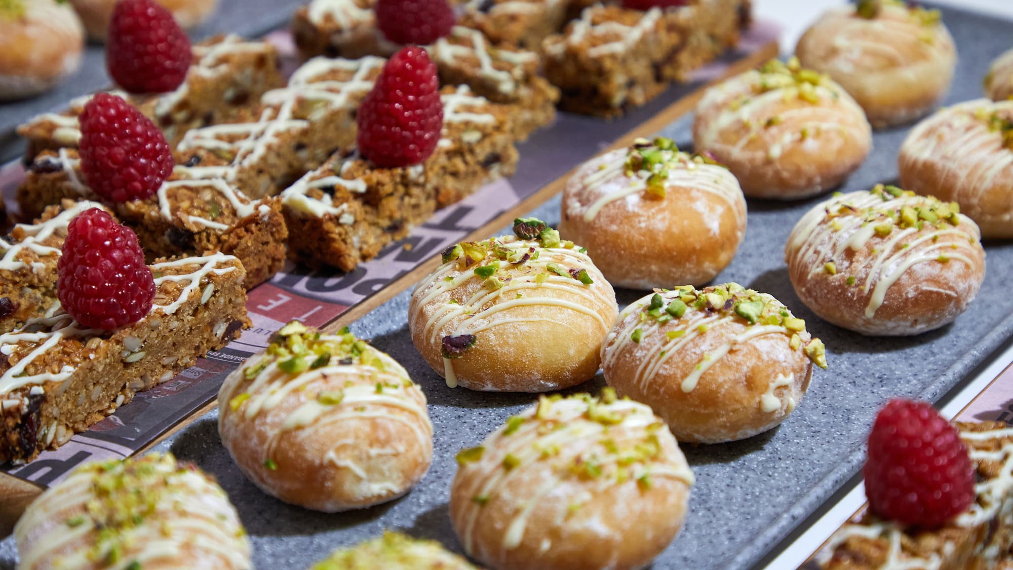 a tray of pastries with raspberries on top