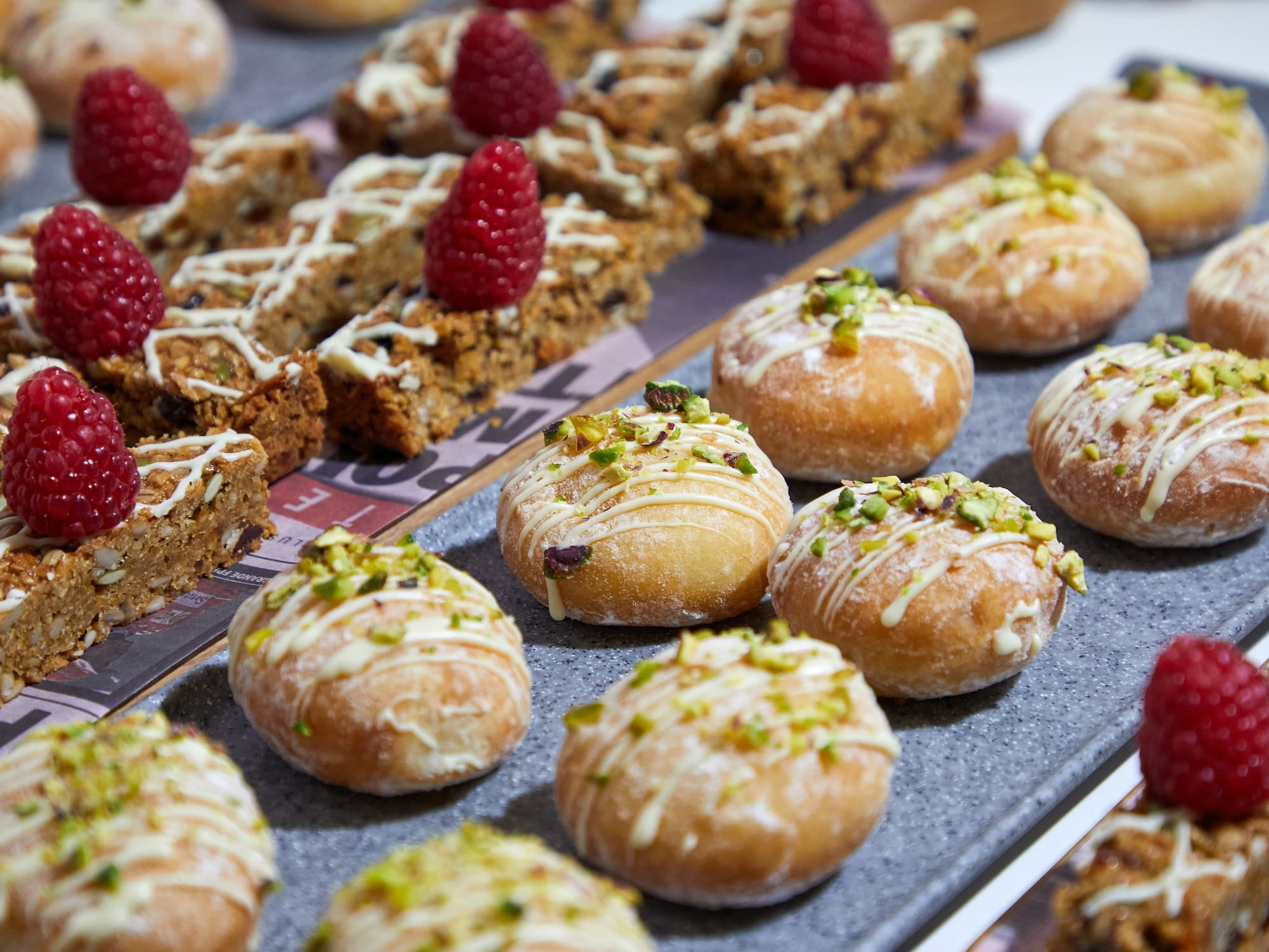 a tray of pastries with raspberries on top