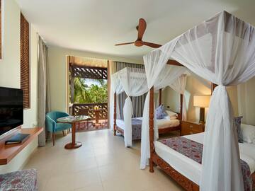 a room with two beds and a table and chairs