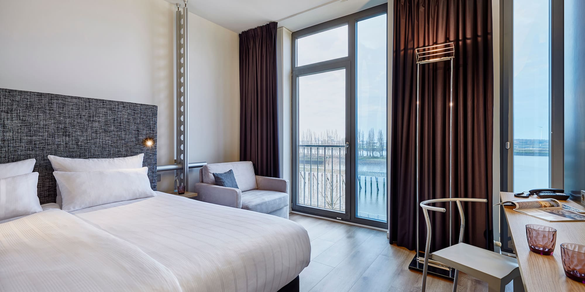 a room with a bed and a chair and a chair