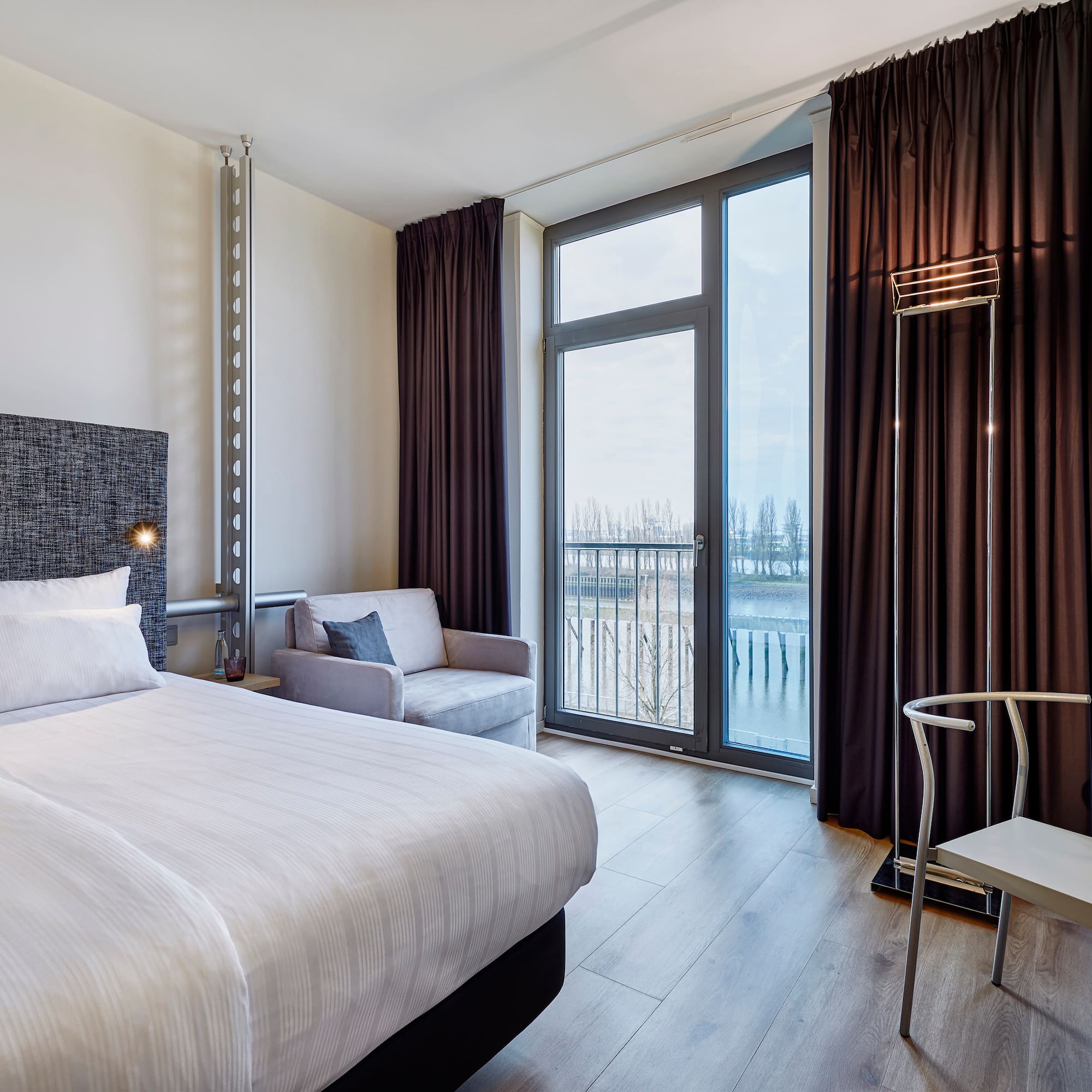 a room with a bed and a chair and a chair