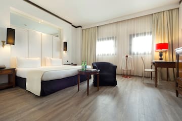 a room with a bed and chairs