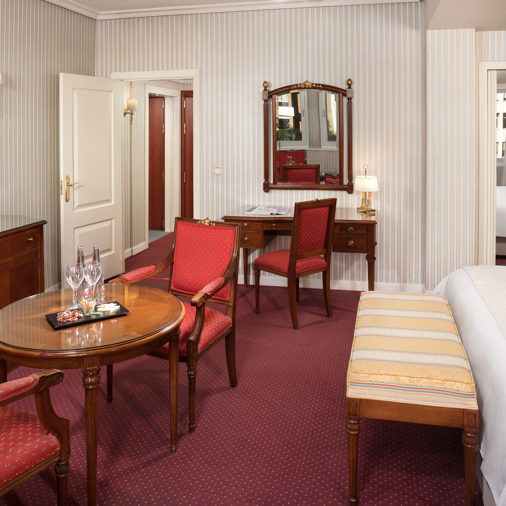 a room with a bed and chairs