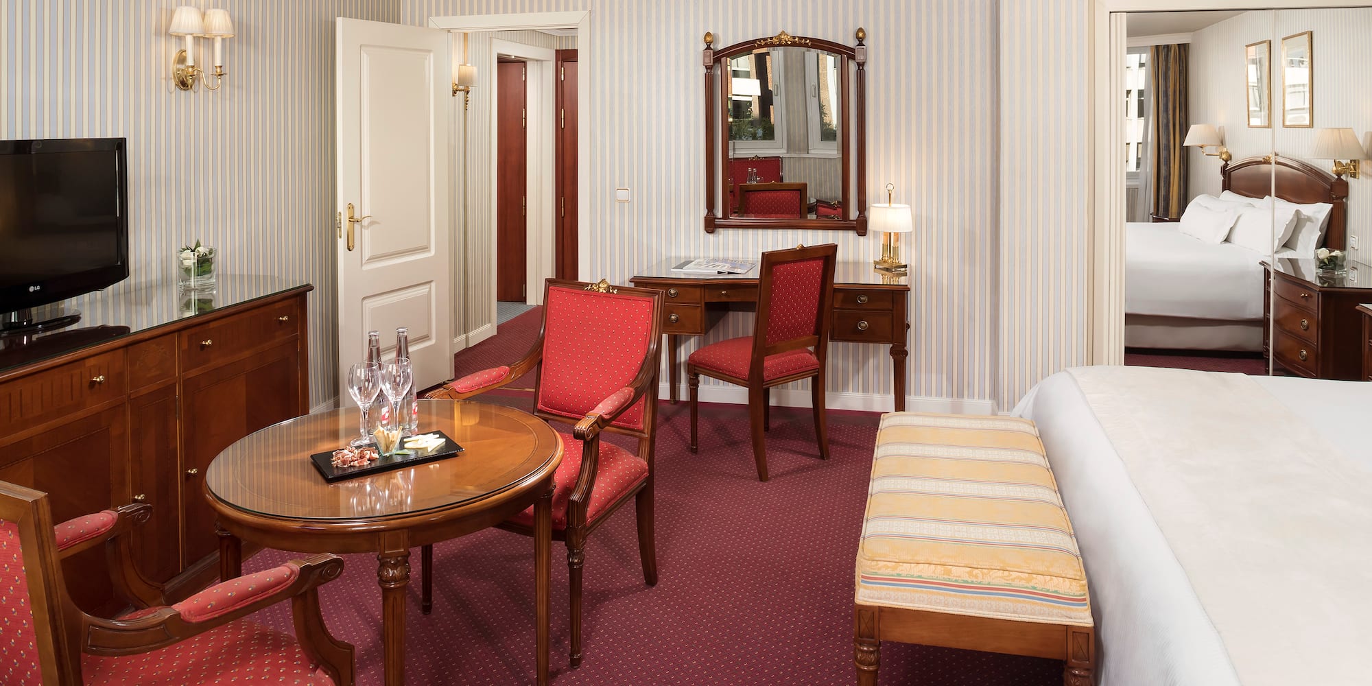 a room with a bed and chairs