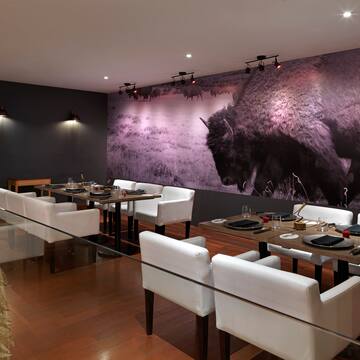 a room with white chairs and tables and a large picture of a buffalo