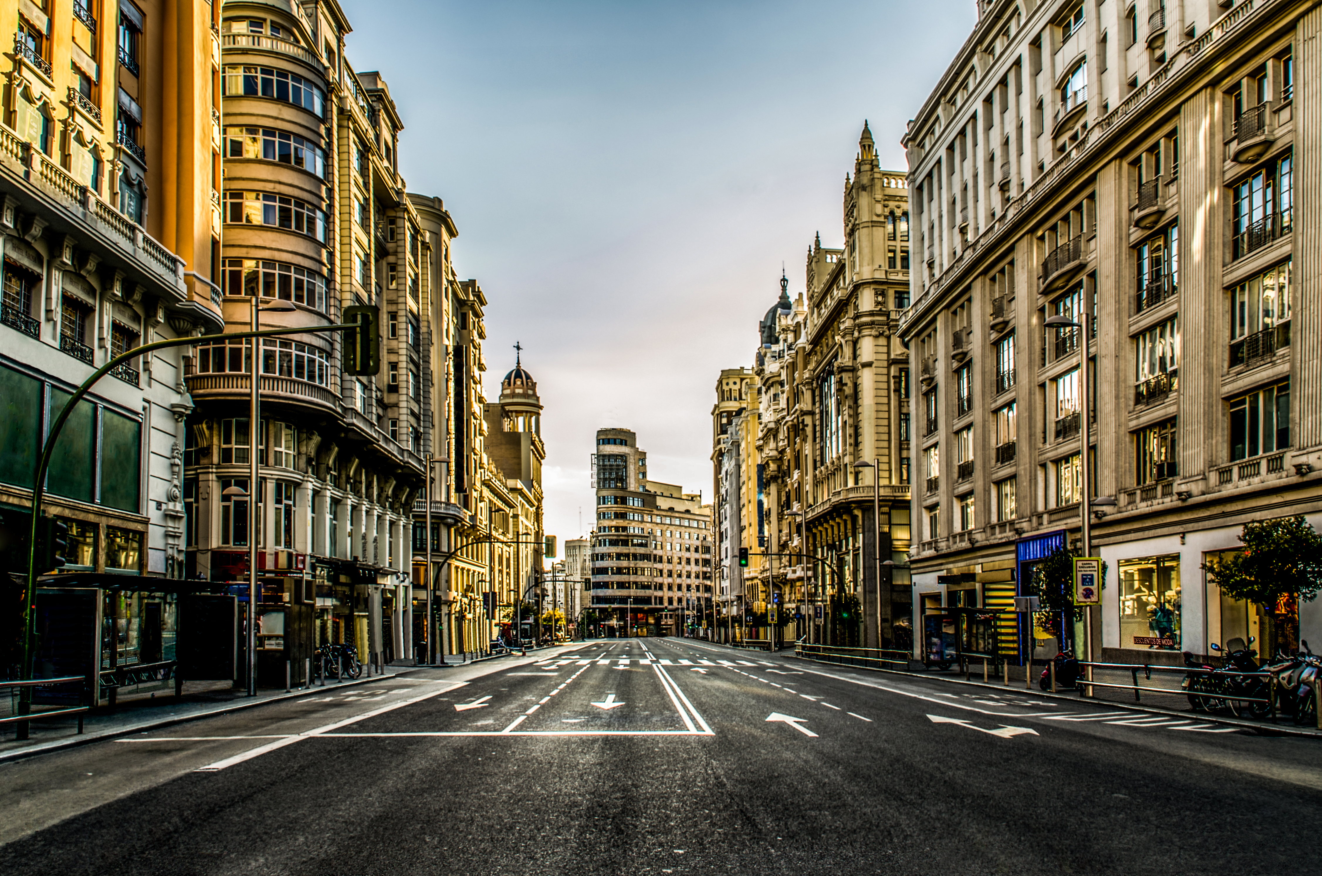Gran Via, Madrid: rua urbana com edifícios majestosos e arquitetura clássica.