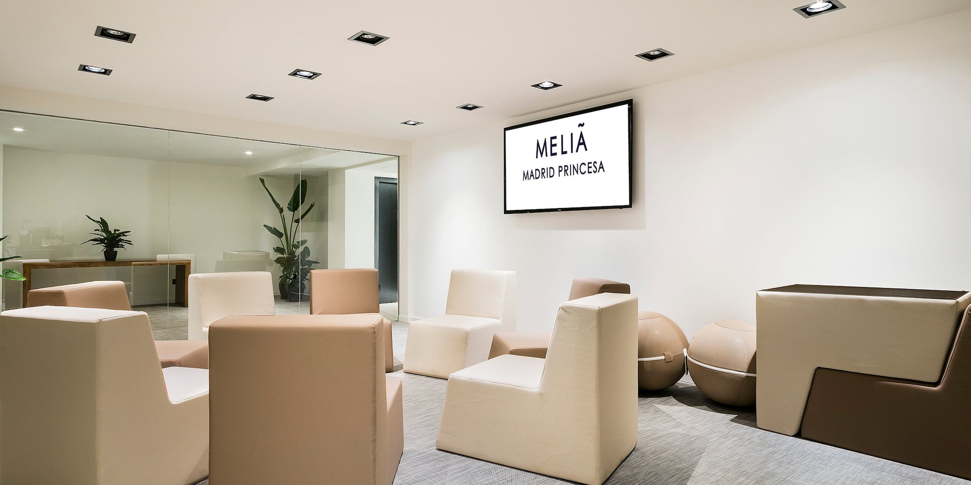 a room with white chairs and a screen