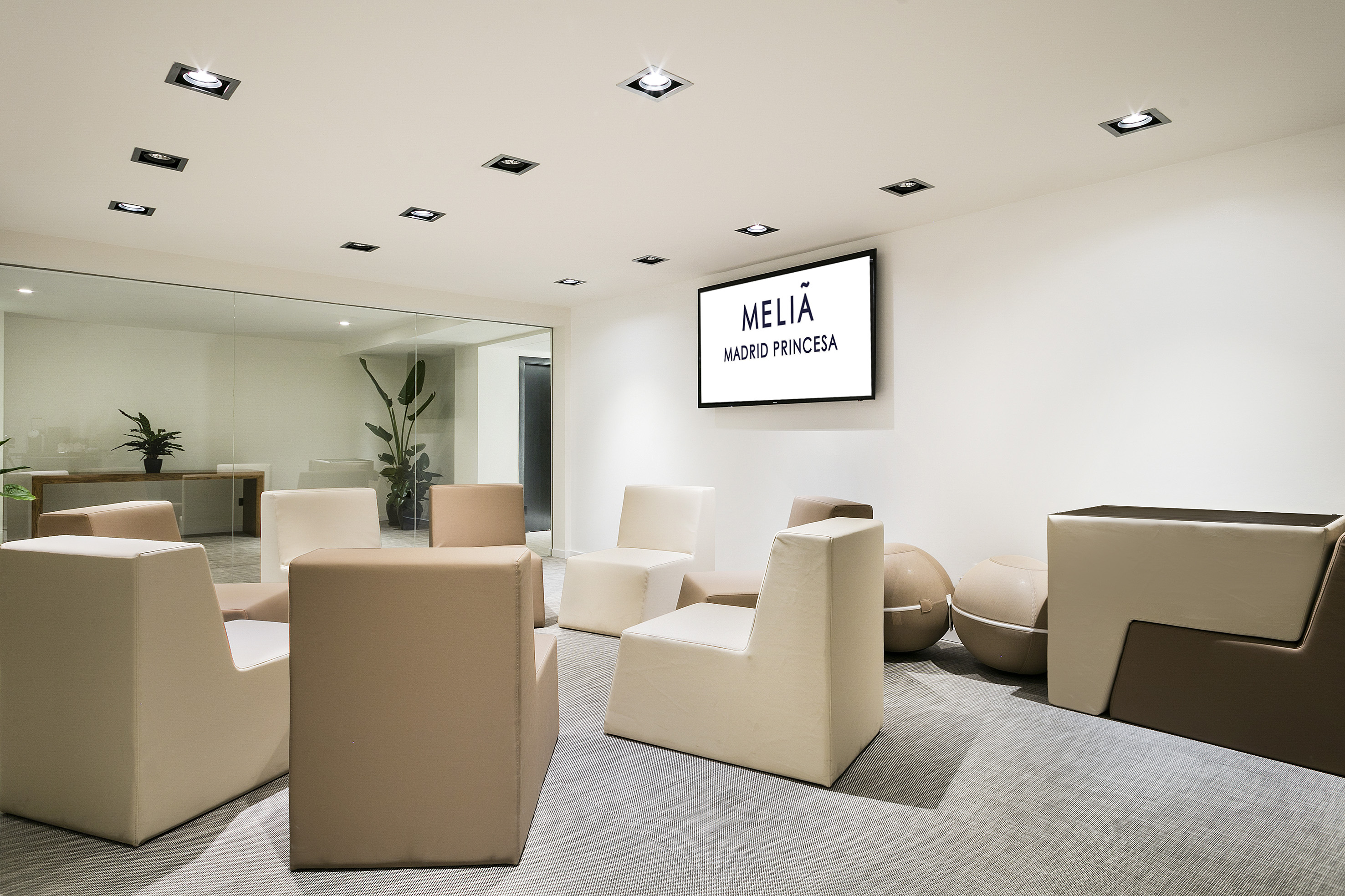 Meliá Madrid Princesa hotel lobby lounge with modern beige seating.