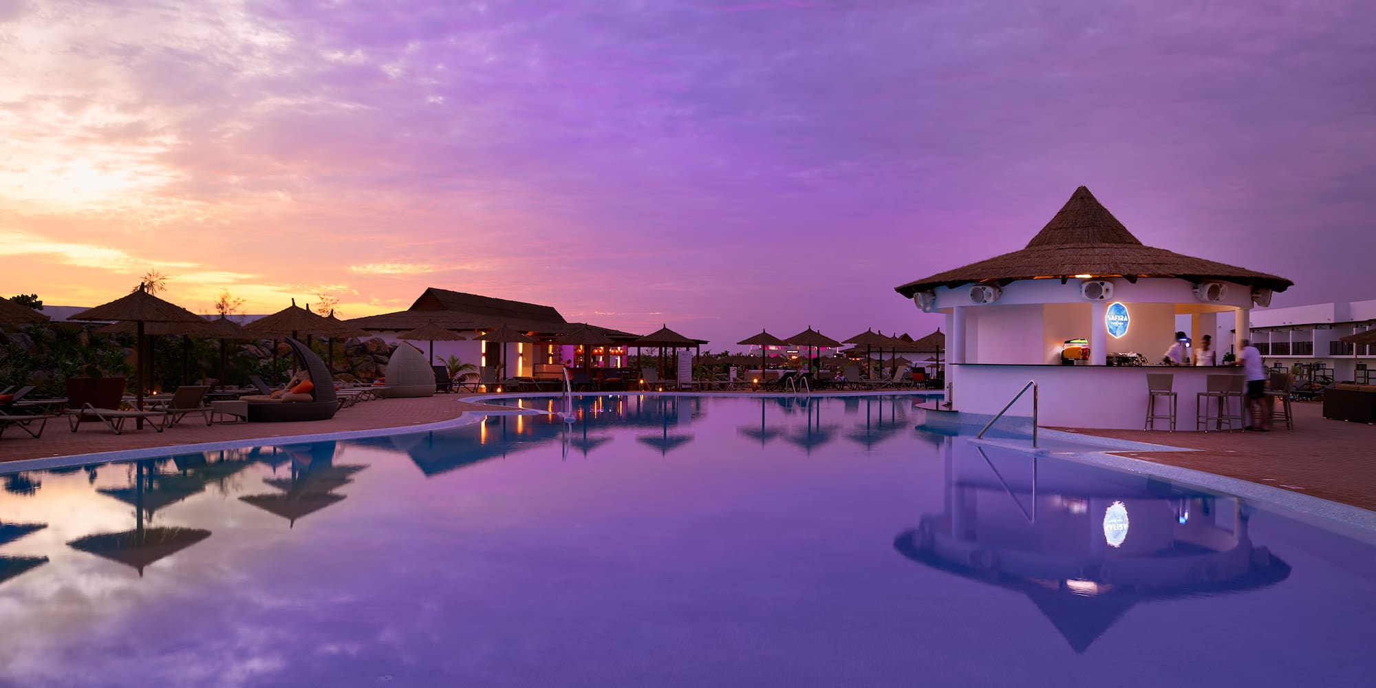 a pool with a building and a bar