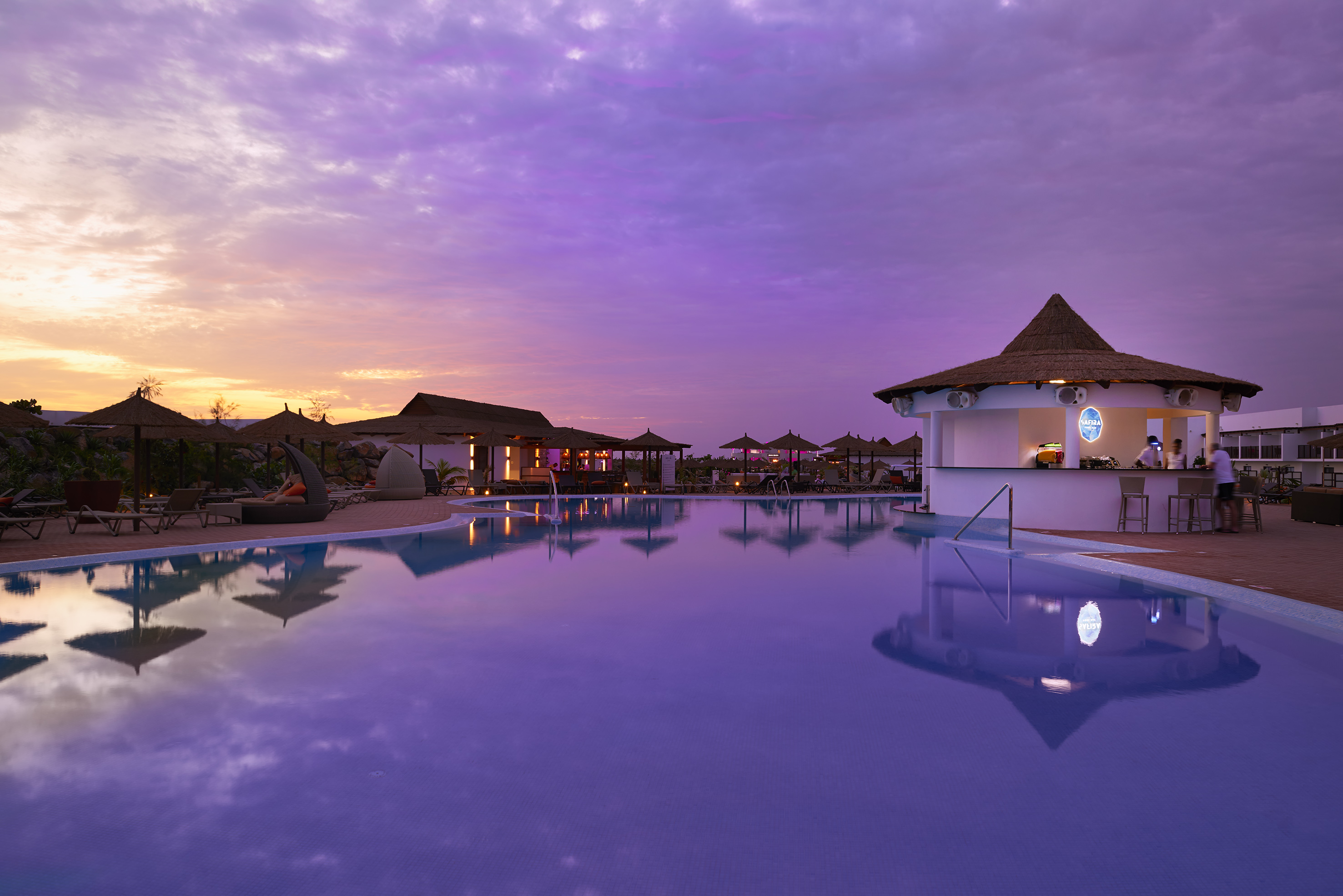 a pool with a building and a bar