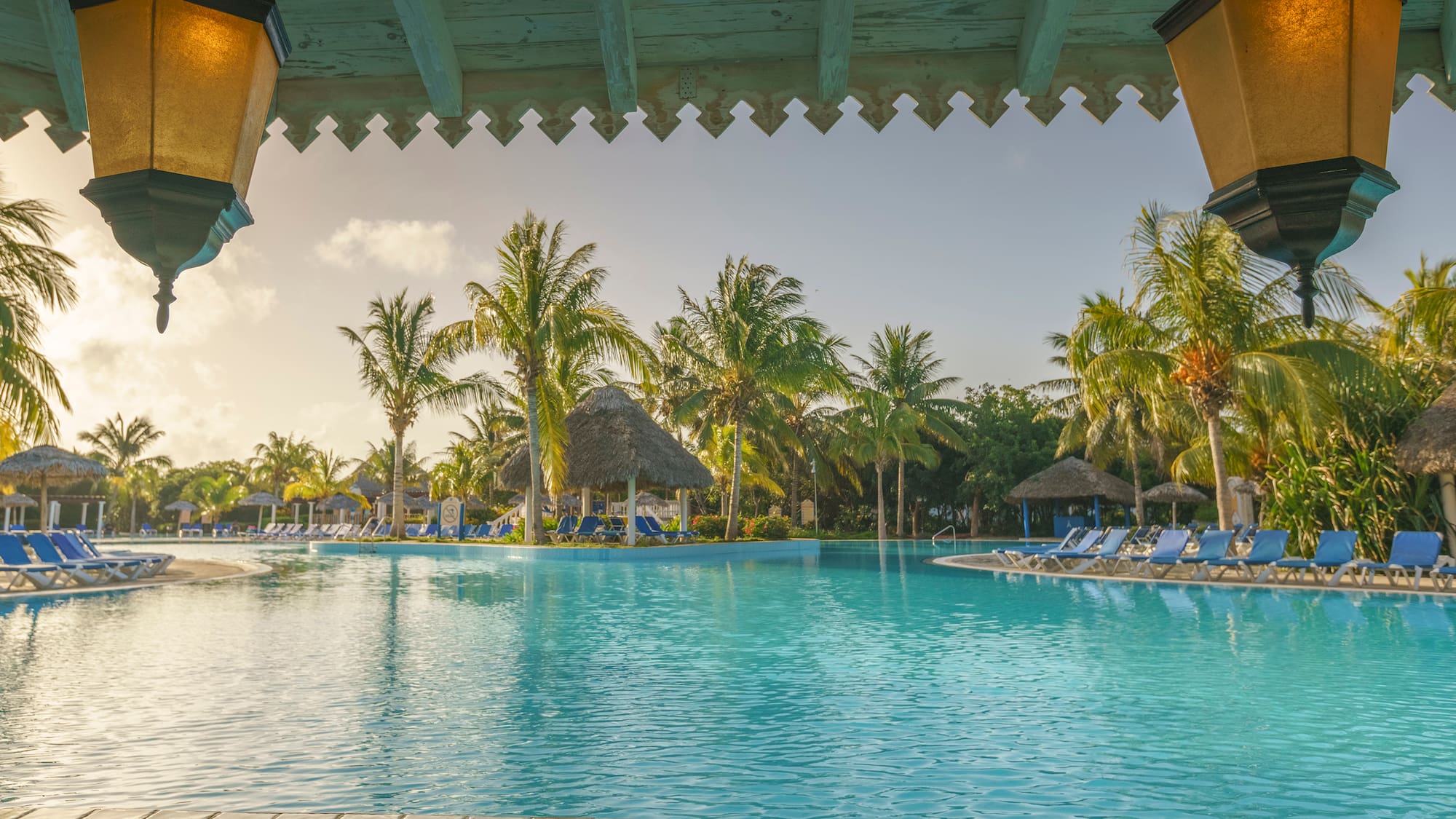 a pool with chairs and trees in the background