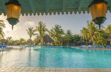 a pool with chairs and trees in the background
