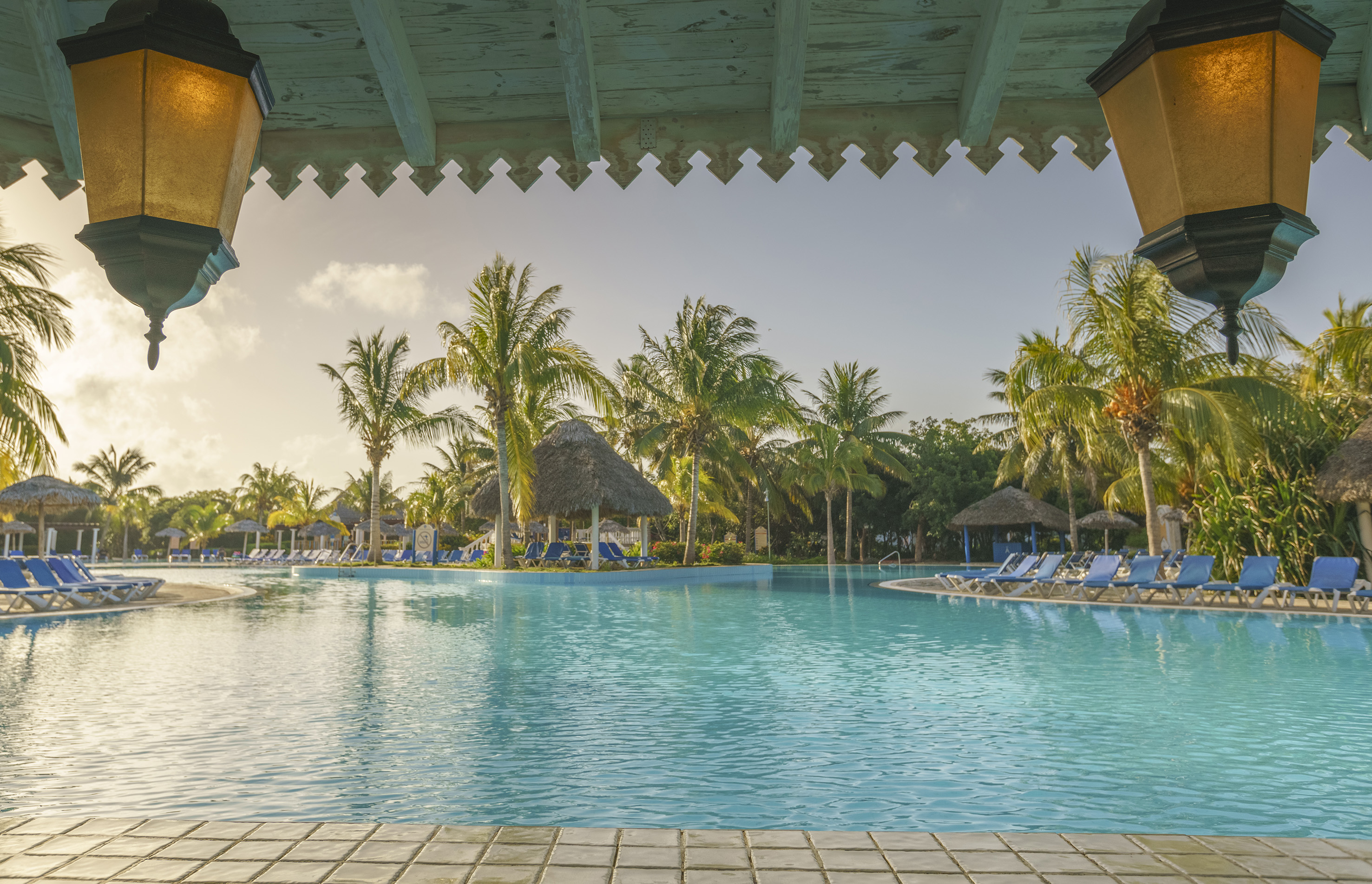 a pool with chairs and trees in the background