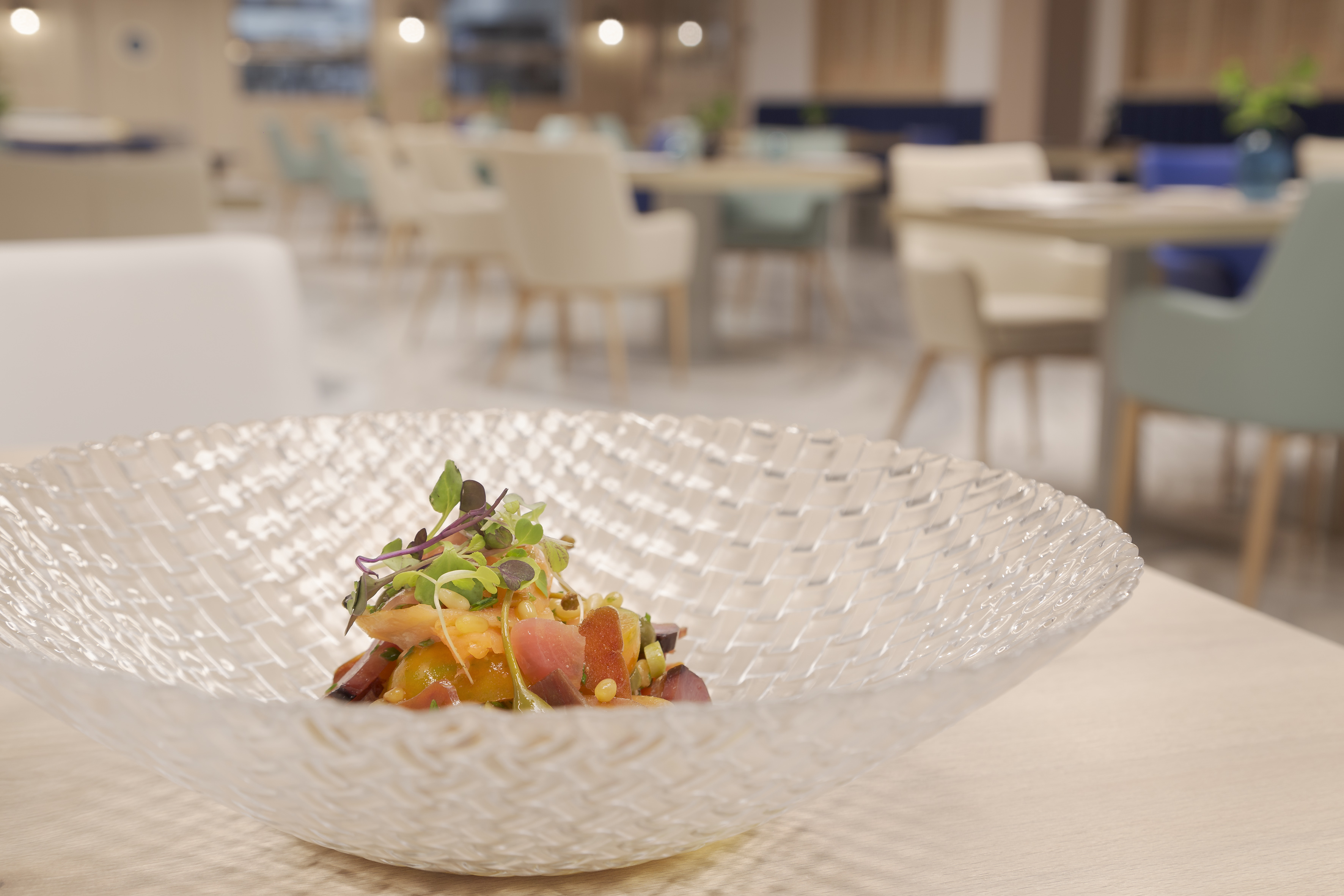 Gourmet dish with colorful ingredients & microgreens in a modern restaurant.