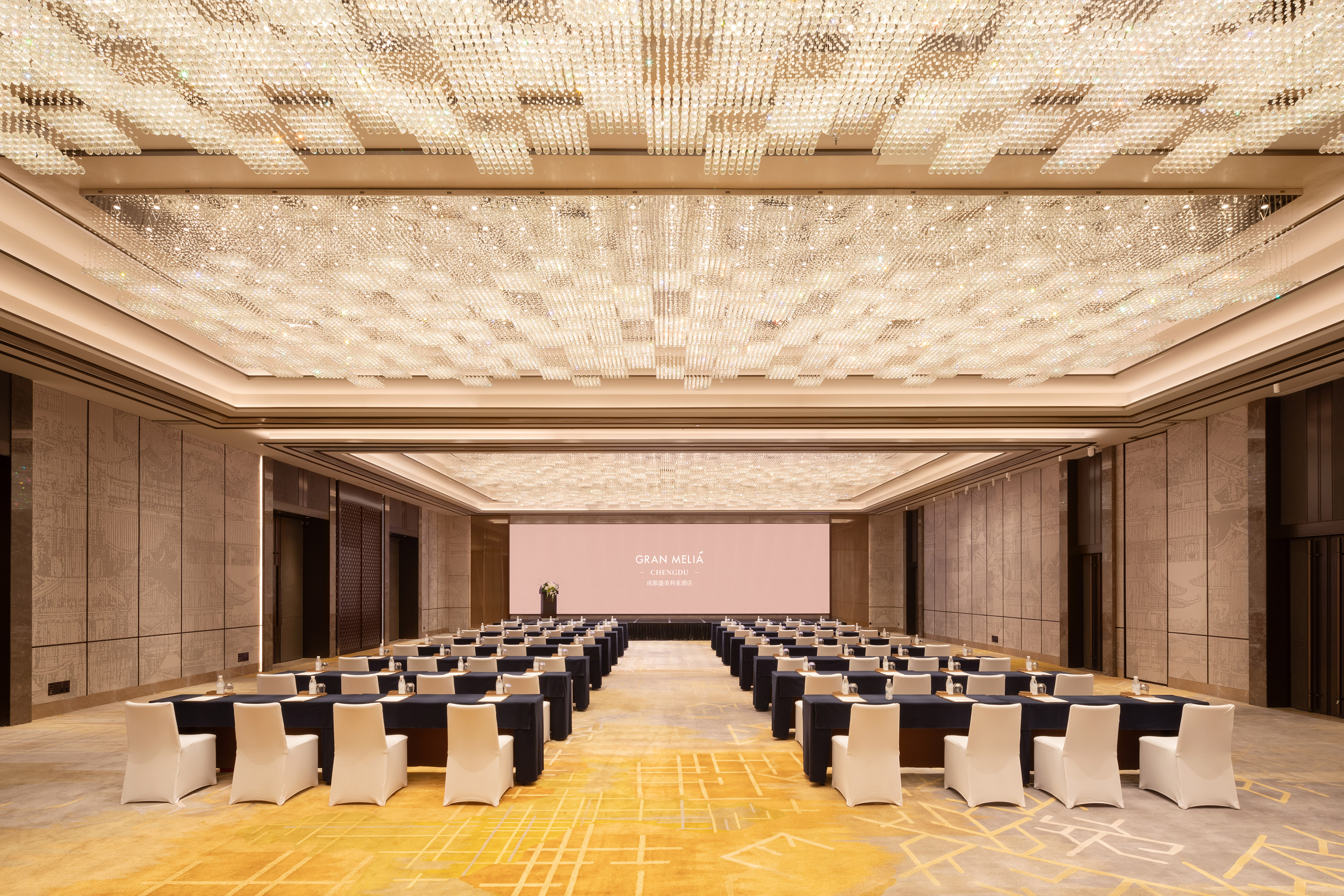 Gran Meliá Chengdu ballroom set for conference, sparkling chandelier ceiling.