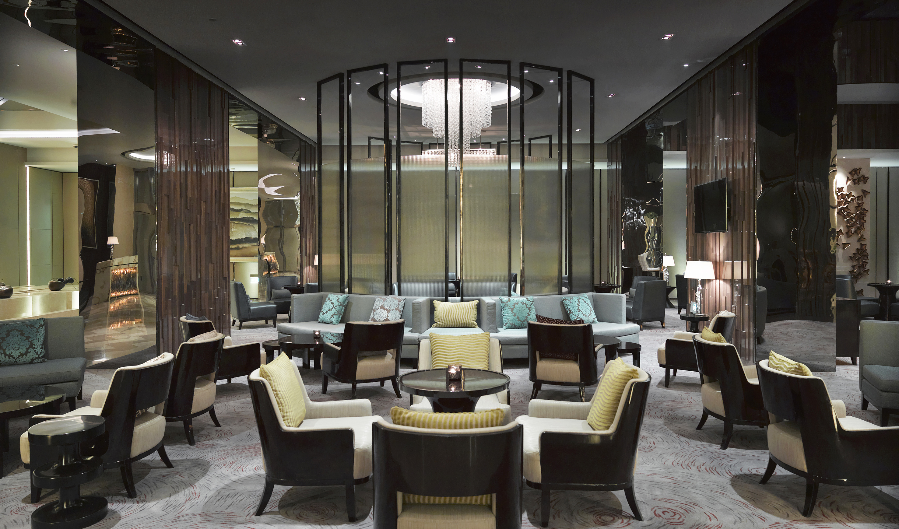Luxury hotel lounge with modern seating arrangements and a grand chandelier.