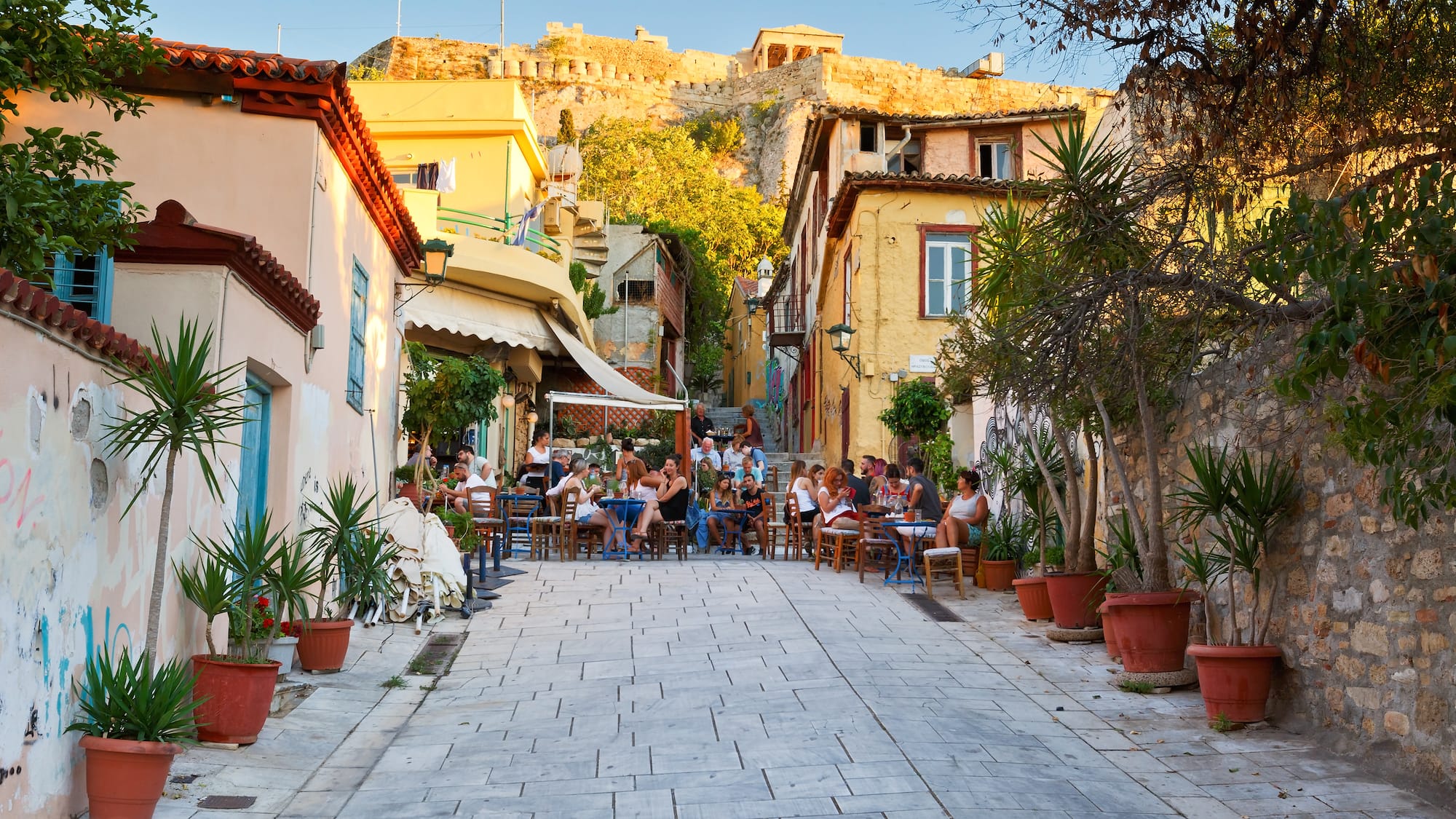 a group of people sitting at tables in a street