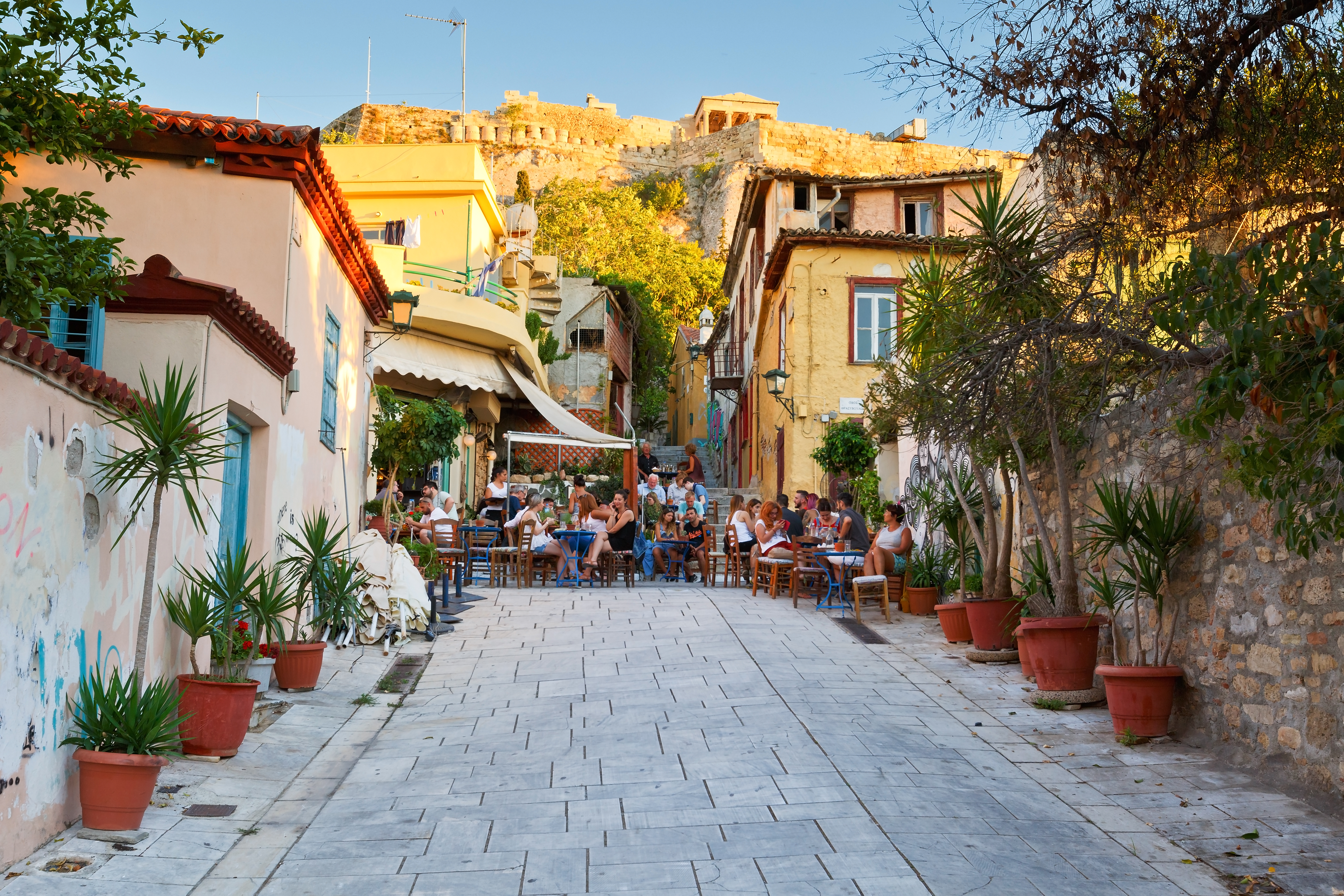 a group of people sitting at tables in a street